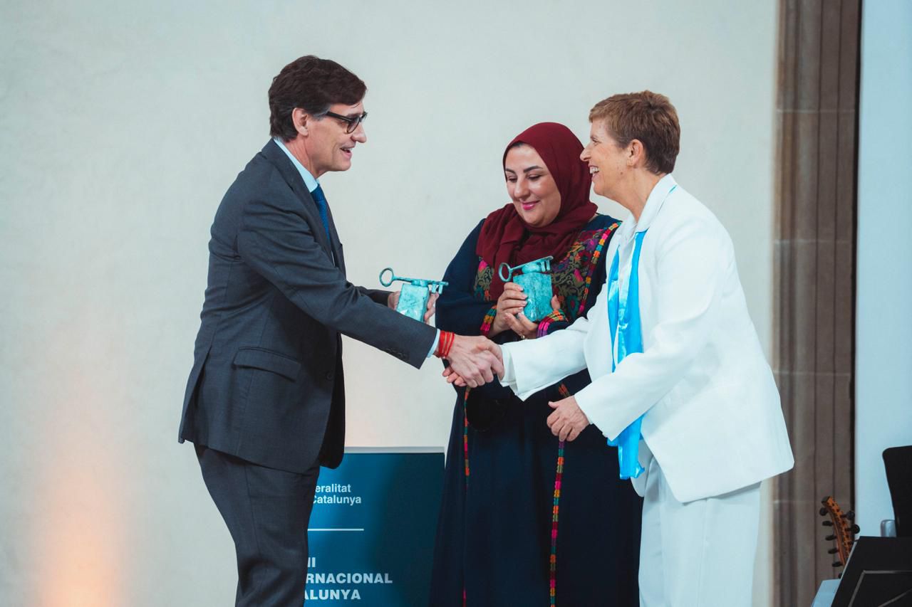 President Salvador Illa shakes hands with Israeli activist Yael Admi before presenting her with the Catalonia International Prize