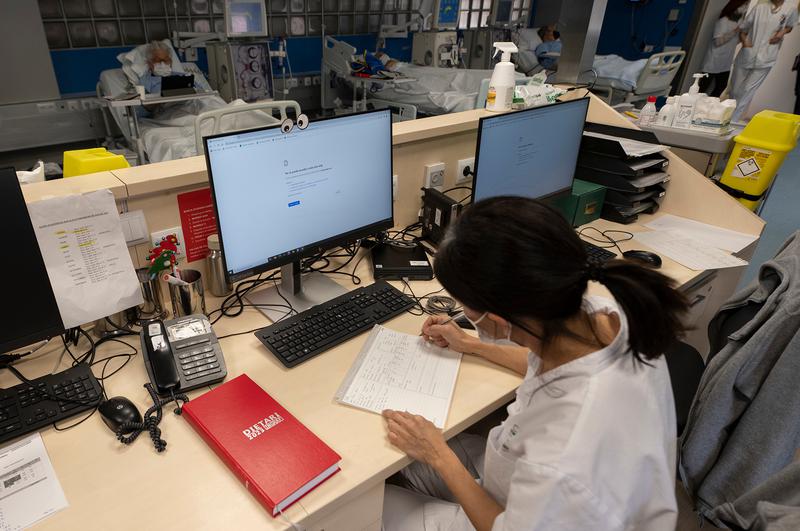 A worker at Hospital Clínic in Barcelona takes notes manually during the cyberattack affecting their normal operations