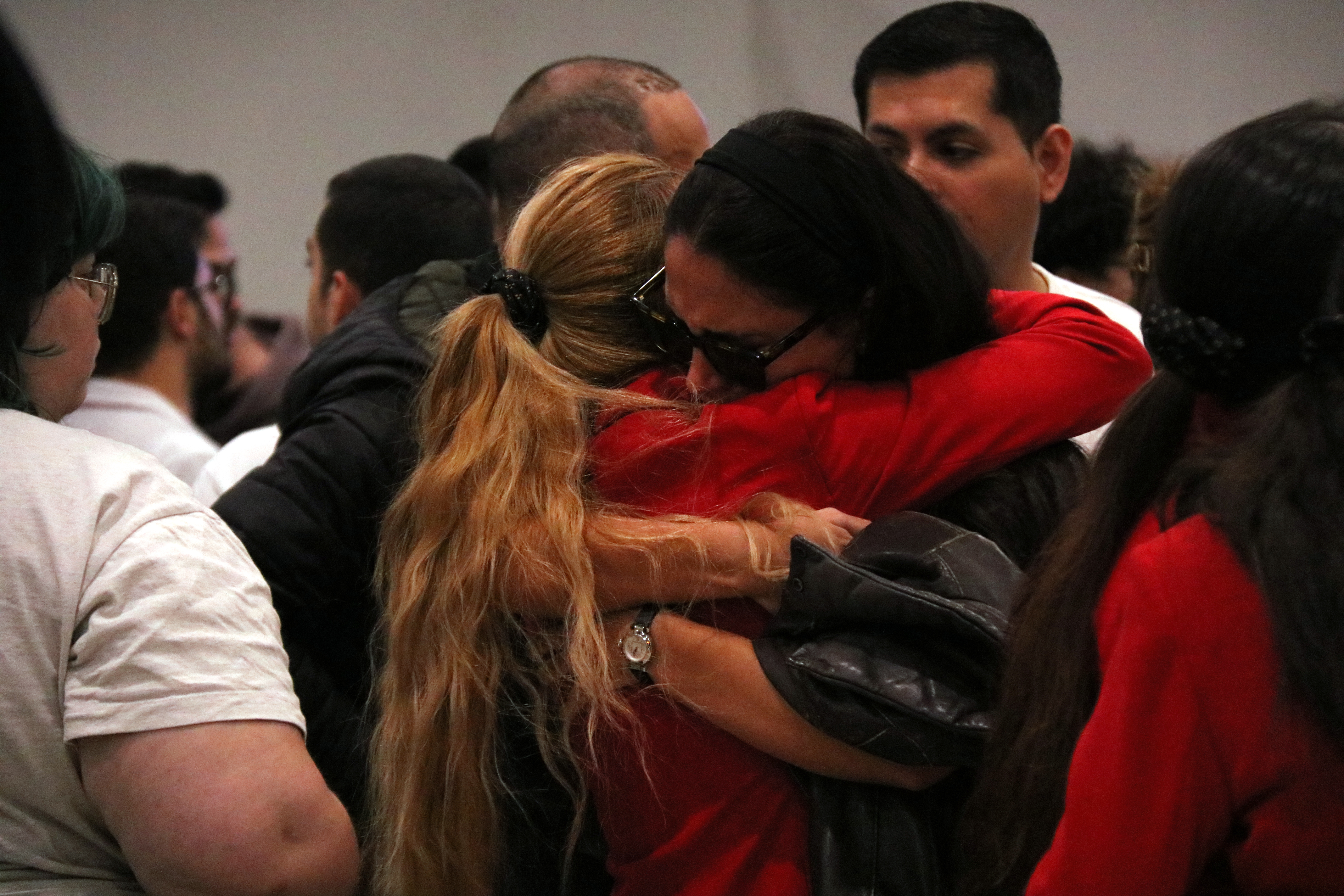 Two Iryo workers embrace during the five minutes of silence at Sants station