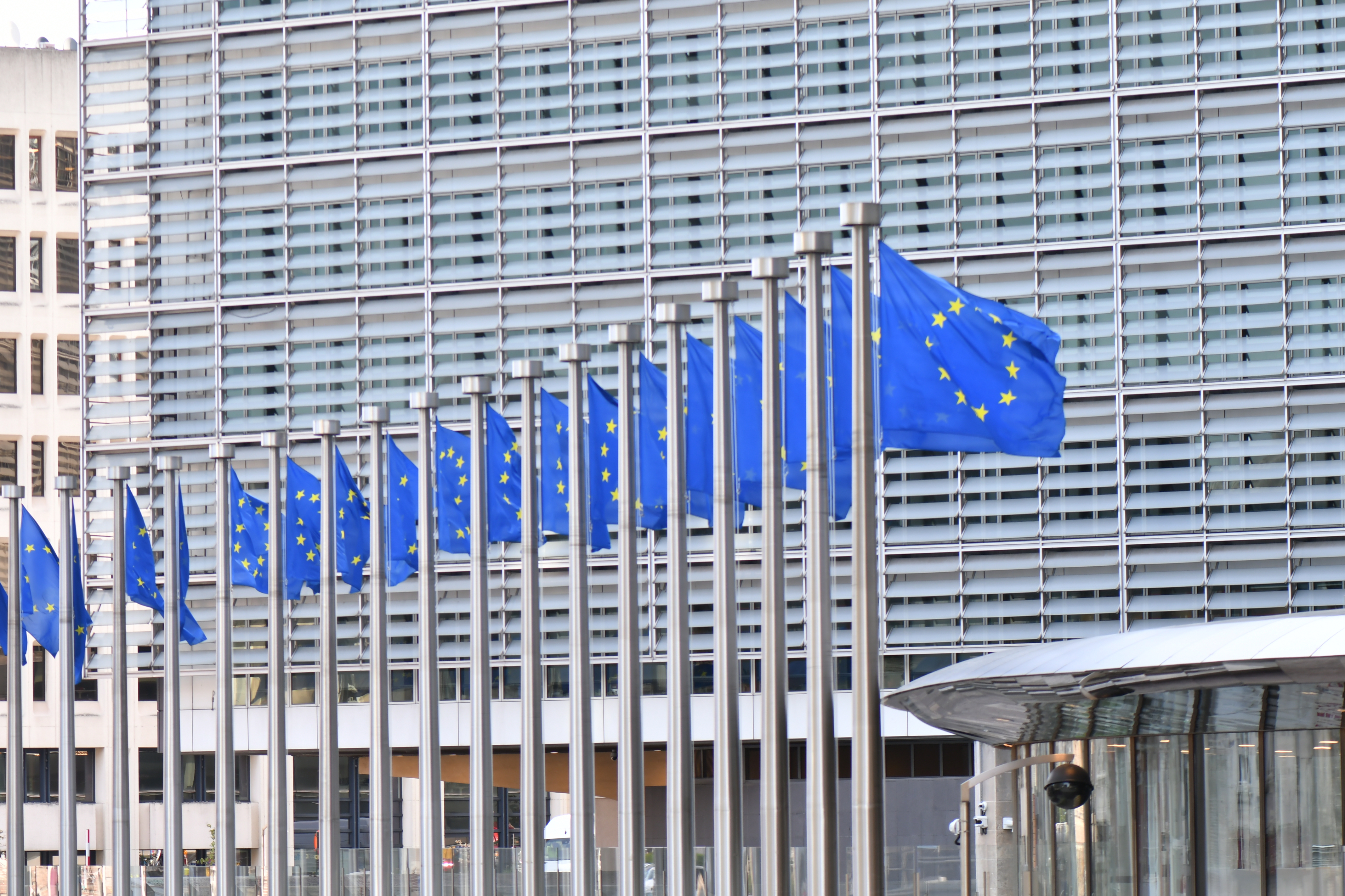EU flags flying in front of the Berlaymont building, the headquarters of the European Commission in Brussels