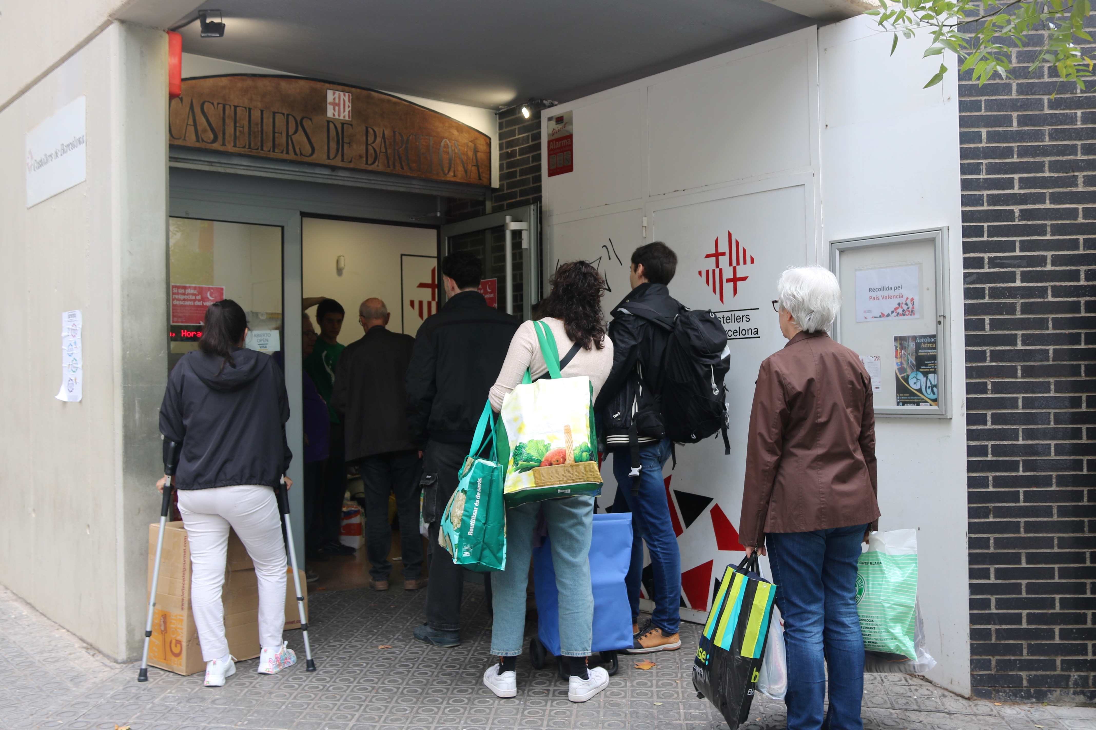 People queue outside the Castellers de Barcelona headquarters to donate aid to be sent to Valencia