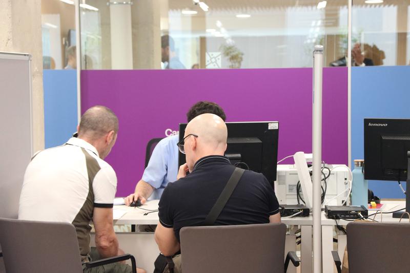 Two people receive in-person support at Catalan Tax Agency (ATC) offices to file their income tax returns