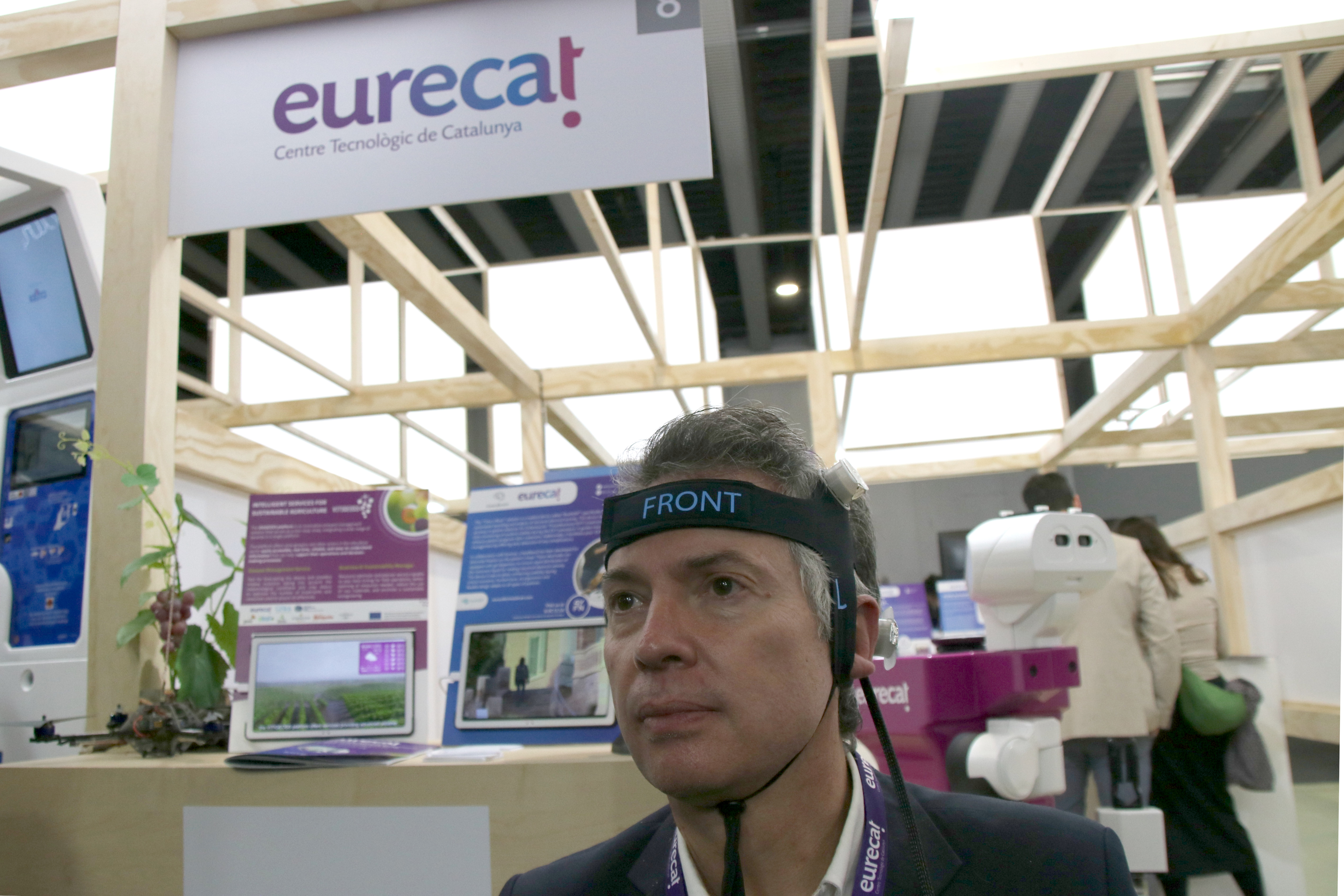 A representative of Eurecat shows off his company's headband designed to collect brainwave data of stroke patients