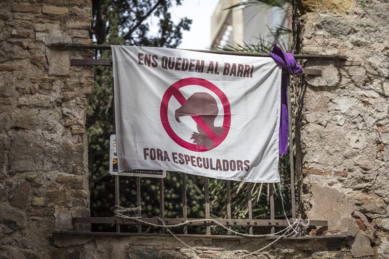 A banner hanging in Barcelona reading 'We're staying in the neighbourhood, speculators out'