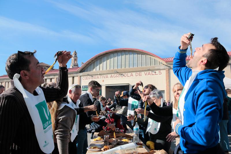 A family from Spain's southern city of Granada taste calçots for the first time during the 2025 edition of the Calçofest in Valls