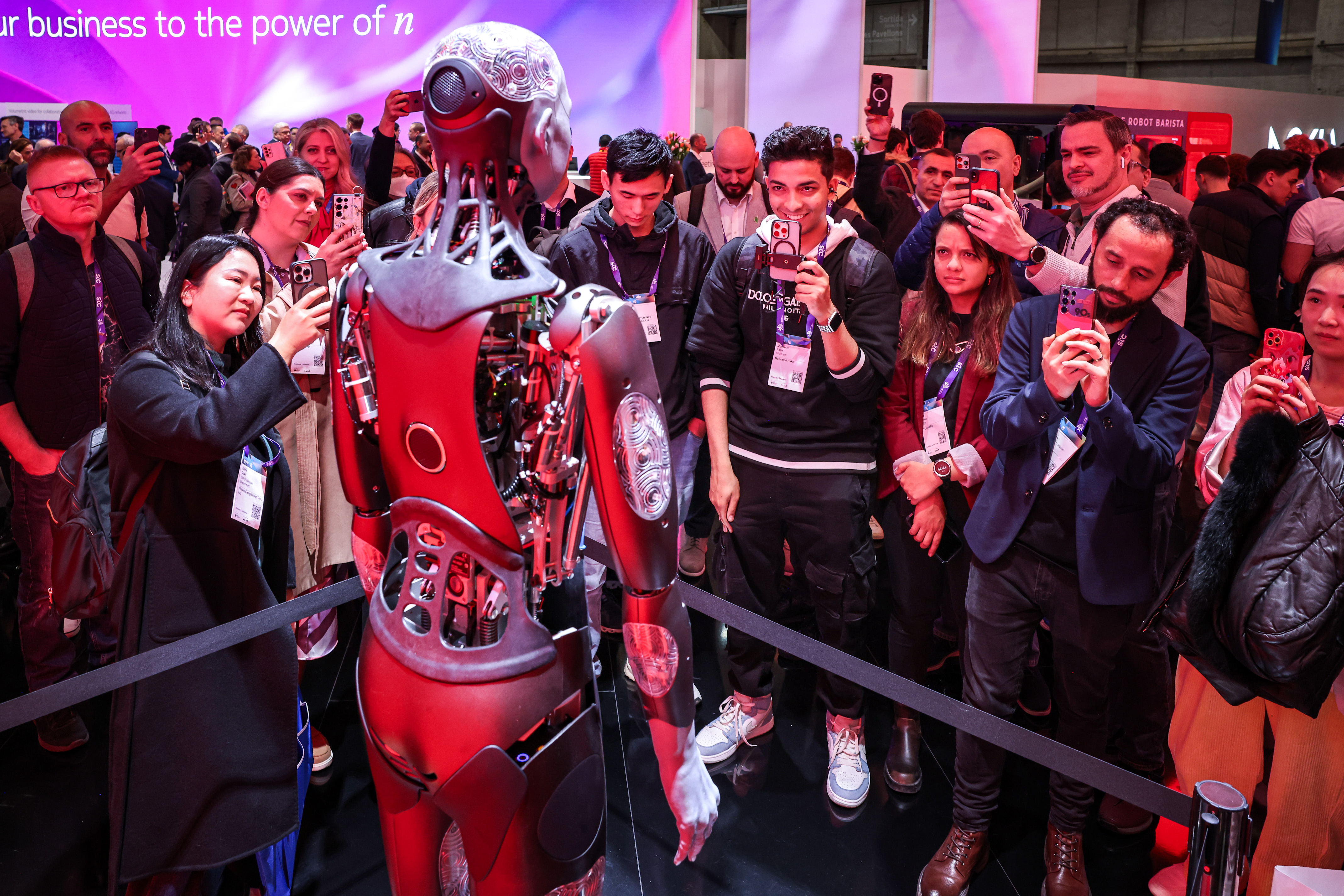 Attendees take pictures of a robot at Mobile World Congress
