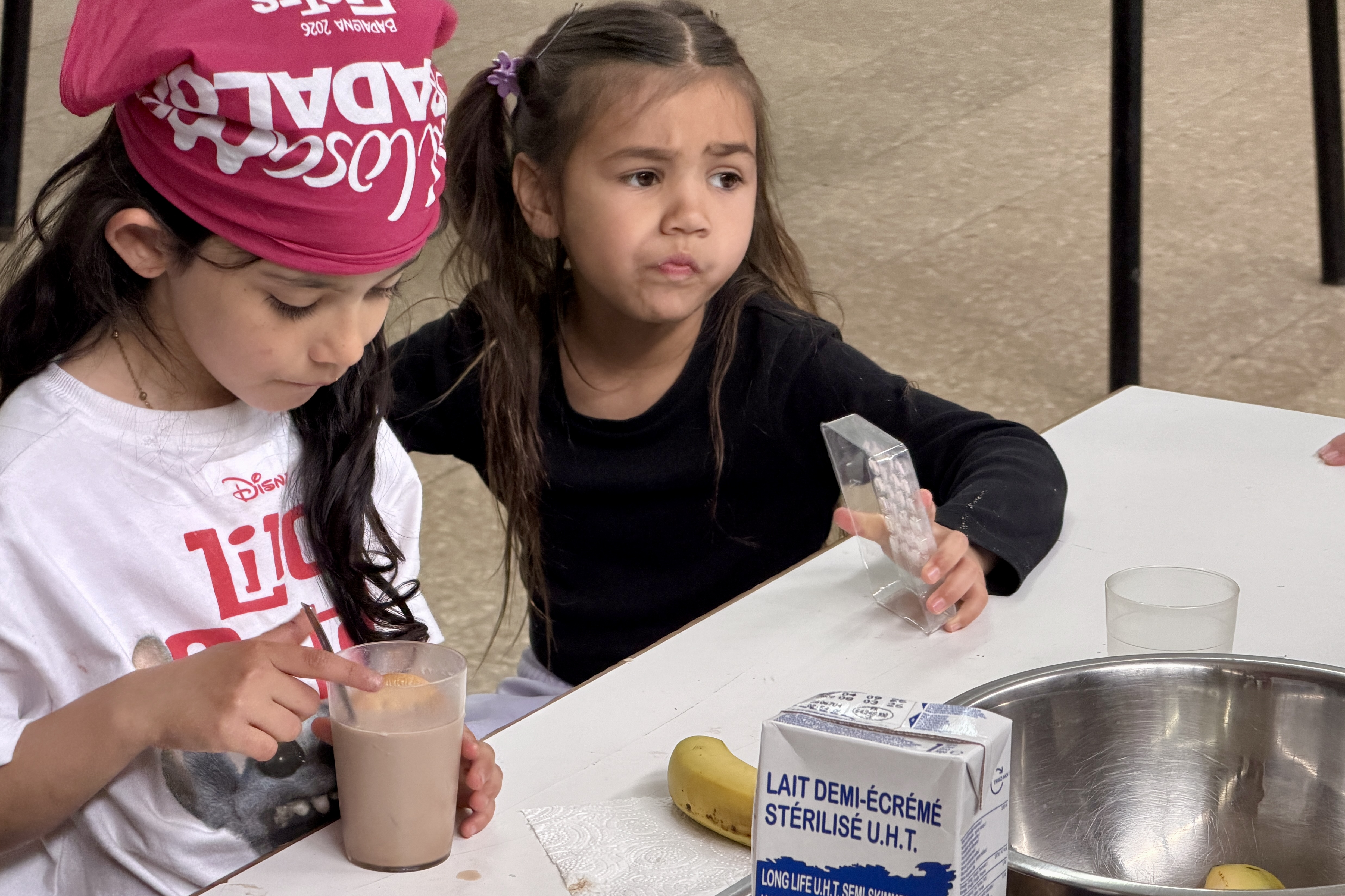 Two girls during snack time at the Ateneu Sant Roc Foundation in Badalona
