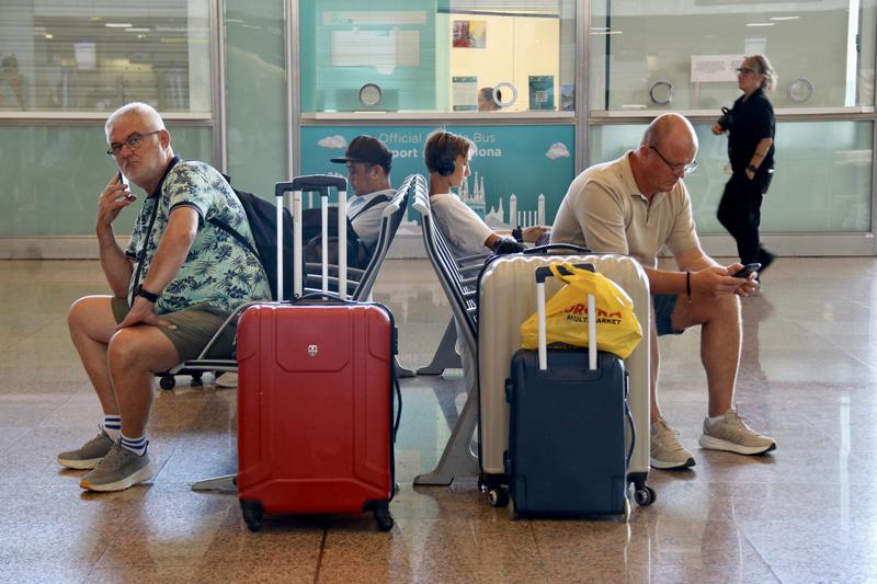 Passengers with suitcases resting at El Prat airport
