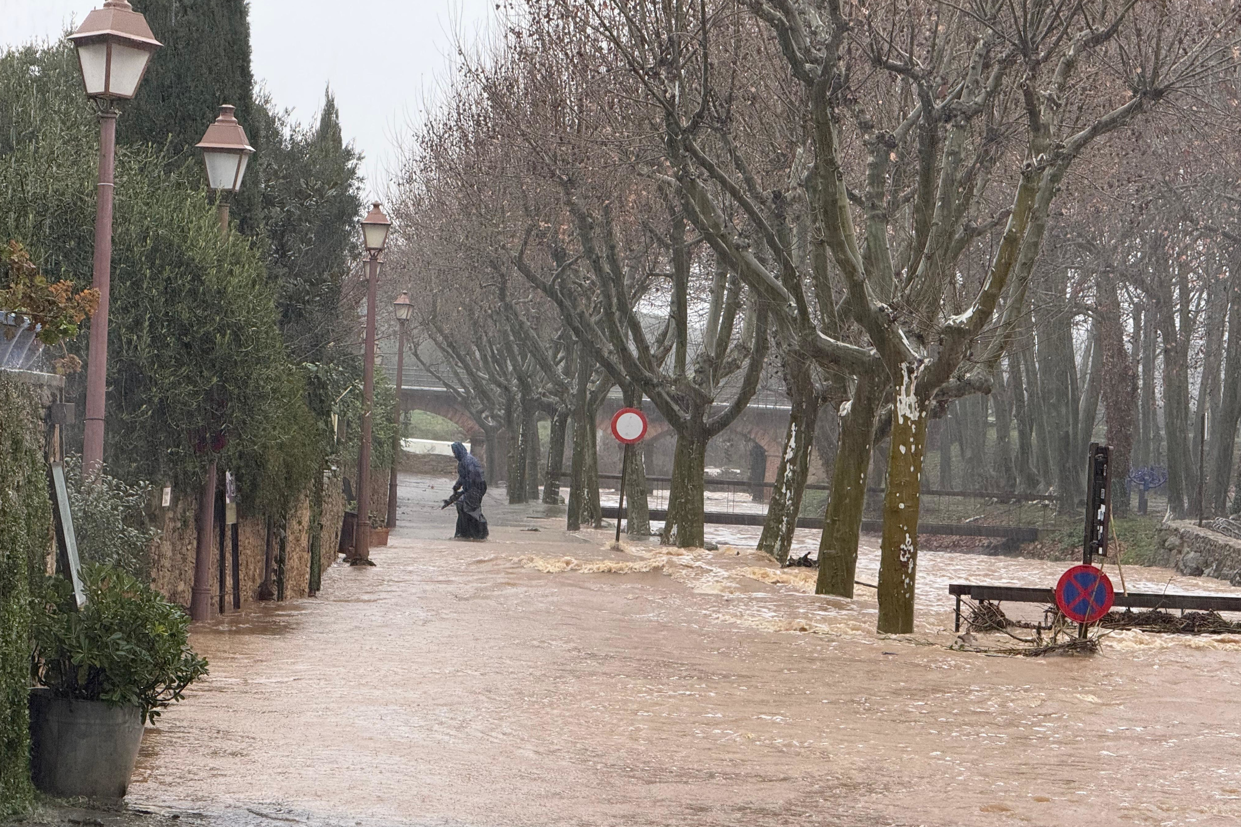 Man walks through flooded street in Peratallada, in Baix Empordà county