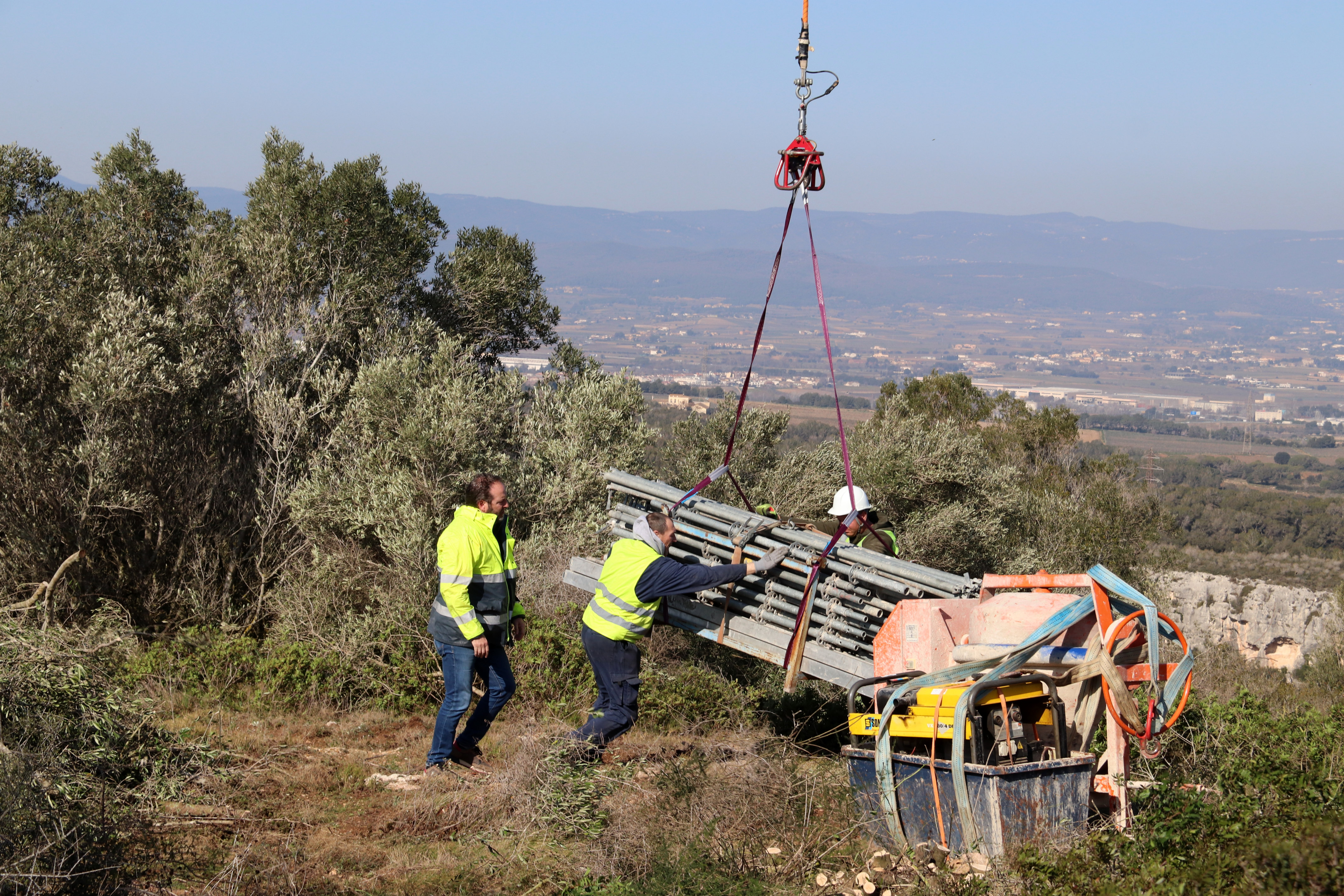 Trasllat amb helicòpter del material de construcció per recuperar parcialment el castell d'Olèrdola