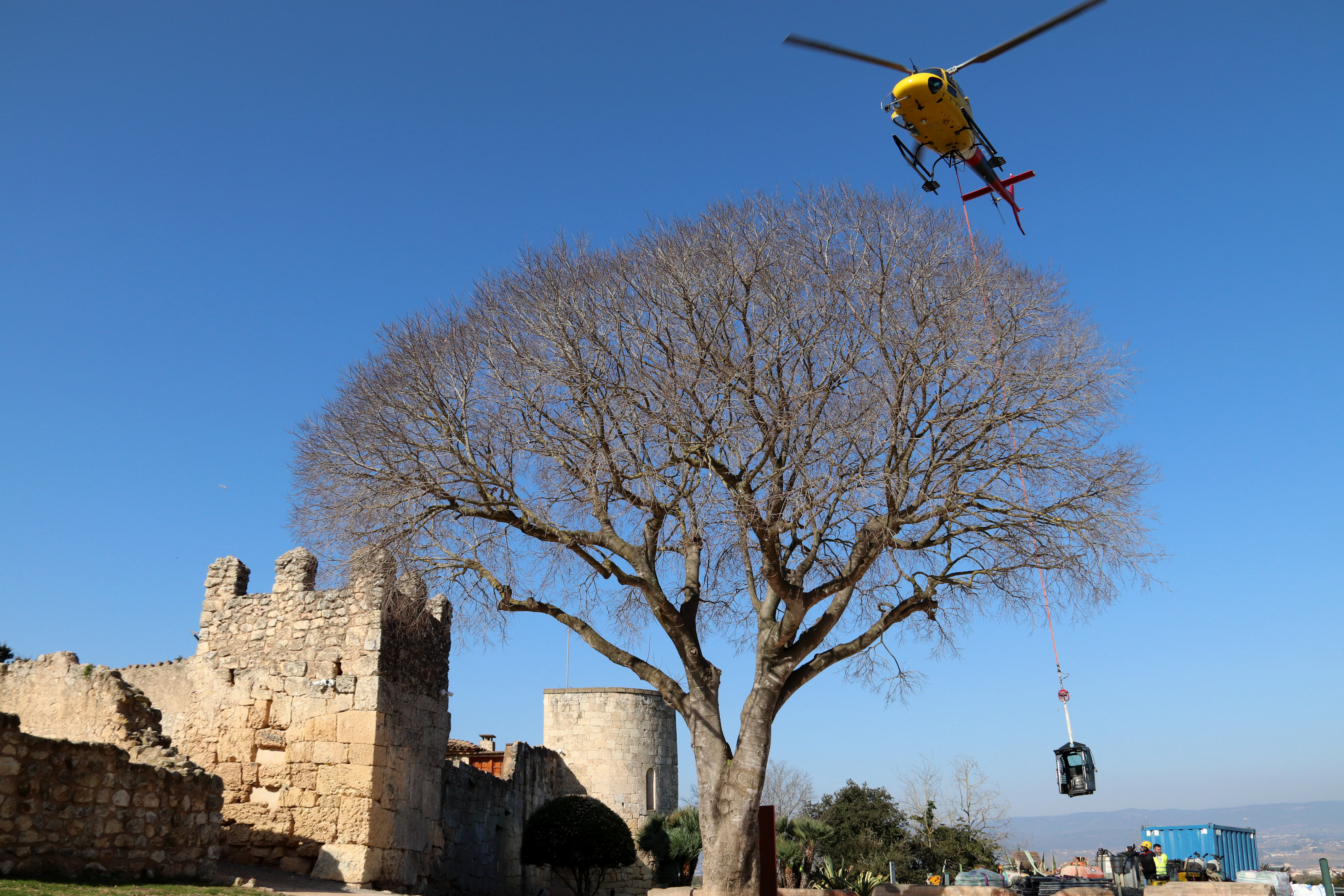 Un helicòpter carrega material d'obra per fer la intervenció al castell d'Olèrdola