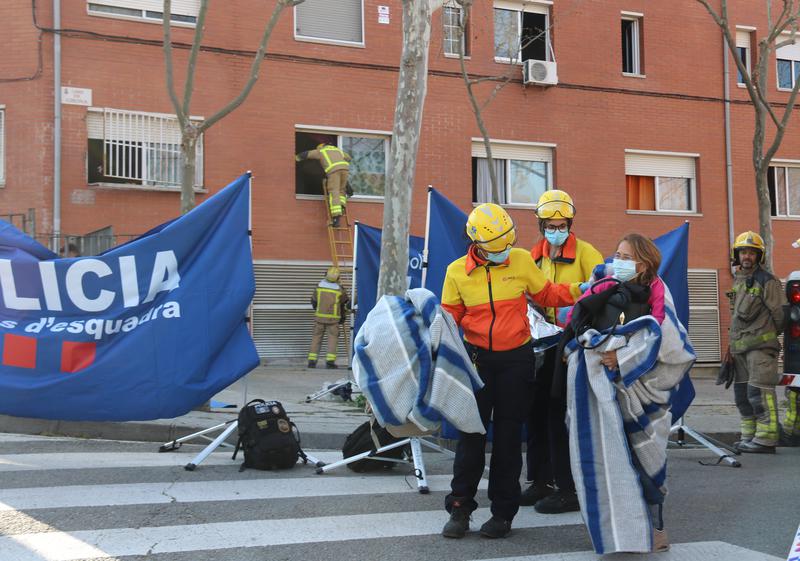 A neighbor is assisted by emergency services following the deadly fire in Rubí 