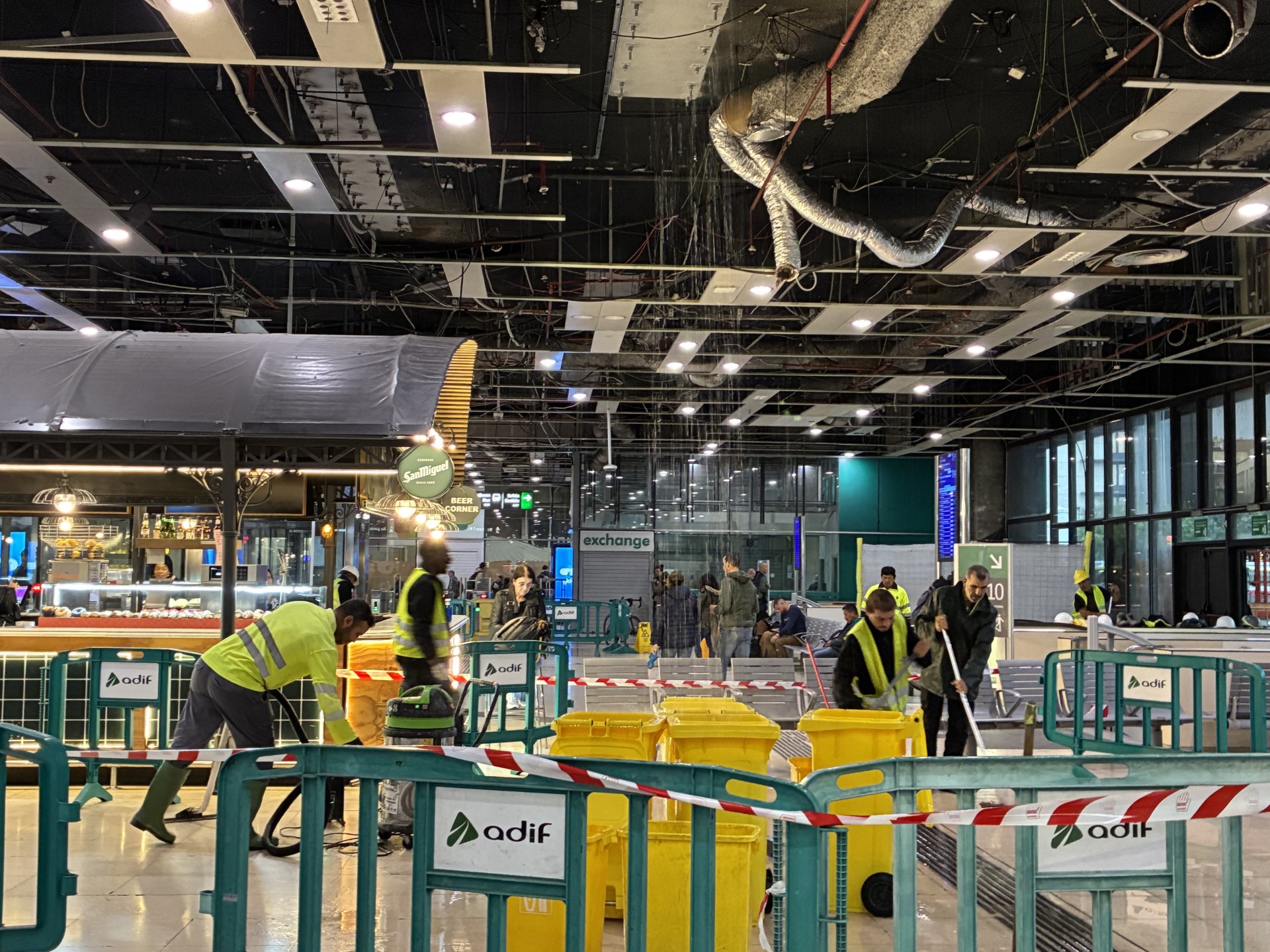 Personal de  l'estació de Sants netegen l'aigua que ha caigut a l'estació arran de les pluges del 6 de novembre