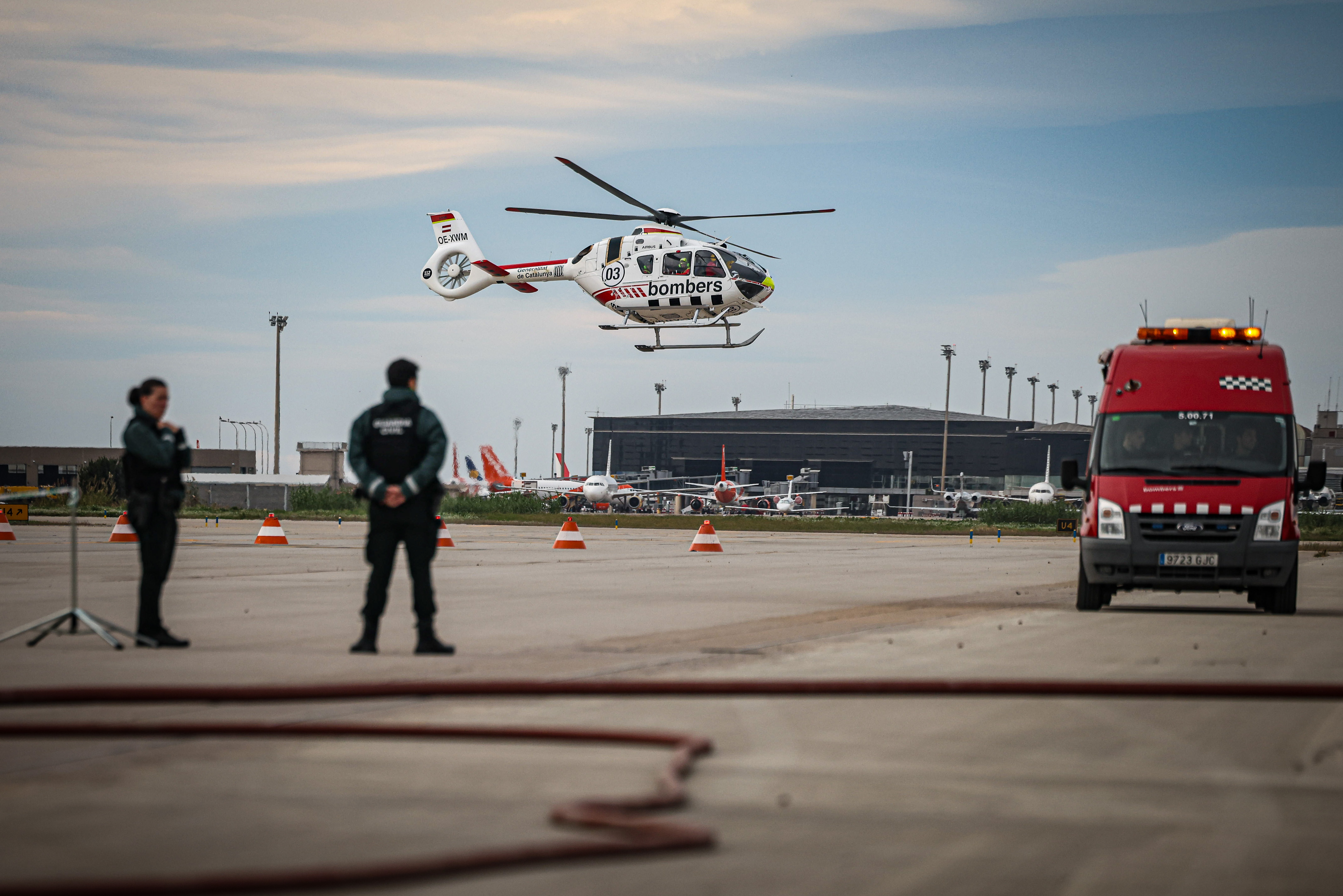 Firefighters, Spain's Guàrdia Civil, and a helicopter during a drill in Barcelona airport on November 20, 2024