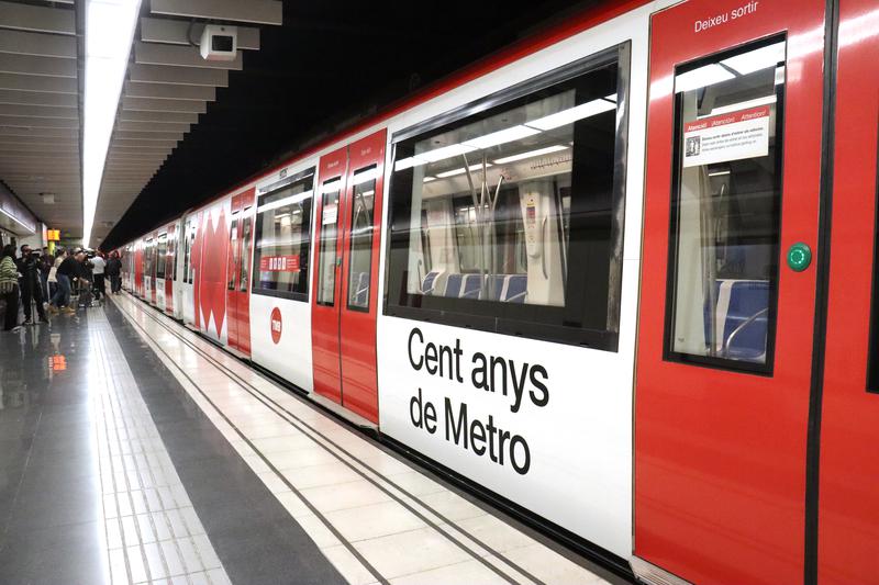 A metro train decorated with centenary celebration text