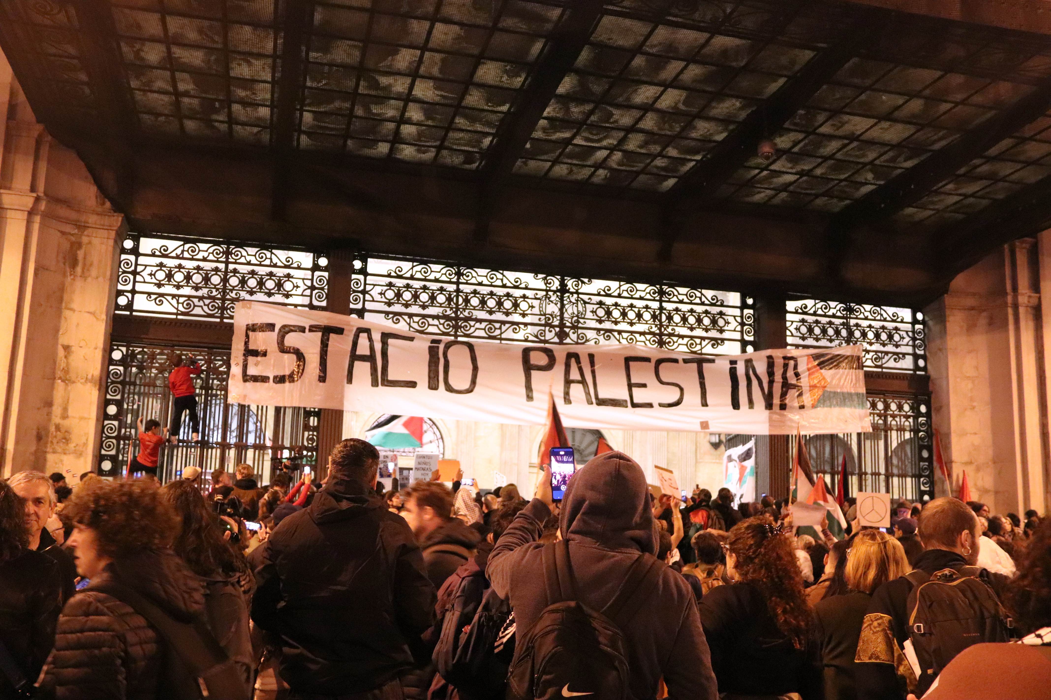 Pro-Palestine protesters hang a poster at Barcelona's Estació de França train station reading 'Estació Palestina' after a demonstration in the Catalan capital on November 11, 2023