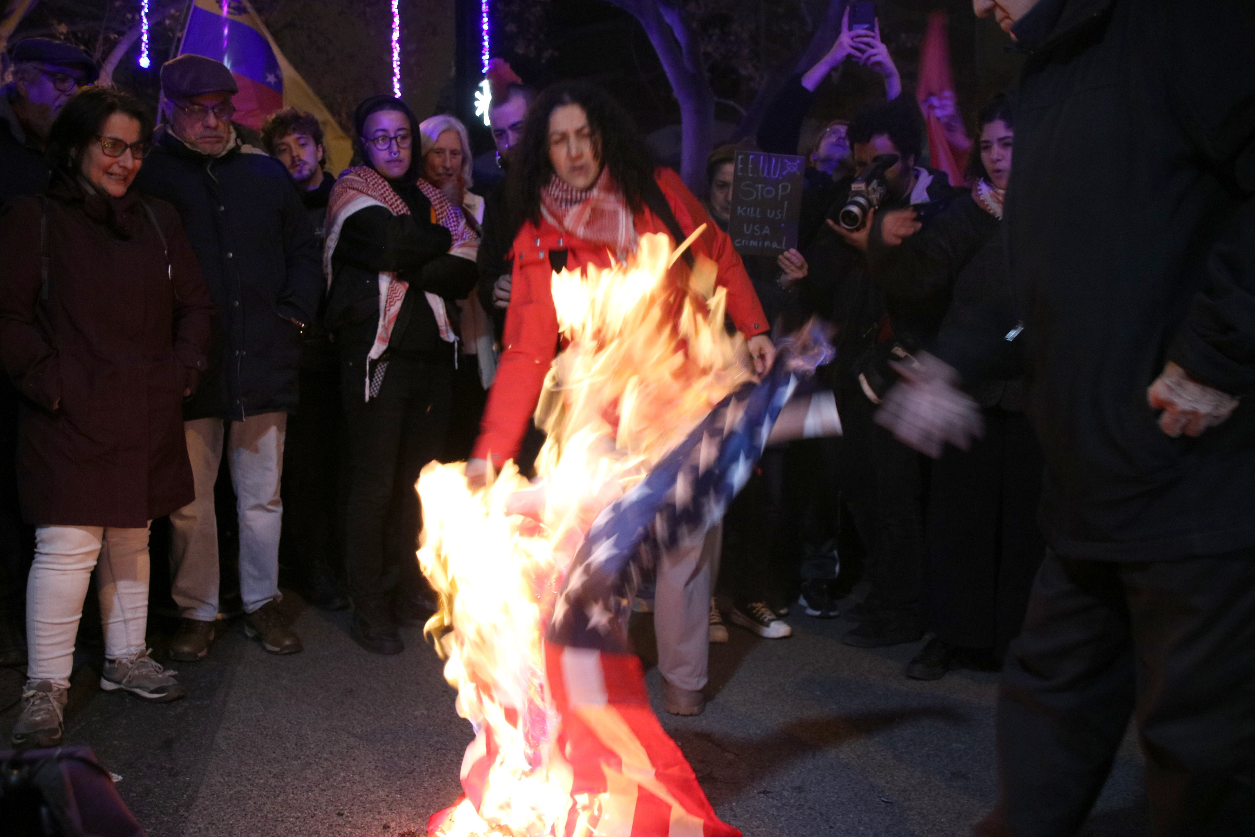 Protesters burn a US flag outside the Venezuelan consulate