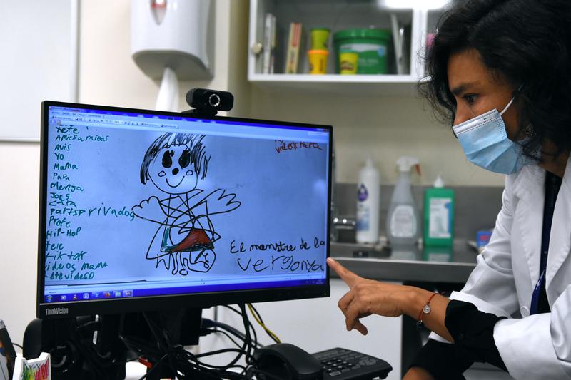 Social worker Giuliana Rios shows a drawing by one of the patients of Vall d'Hebron's EMMA unit, who had difficulty verbalizing the violence she suffered