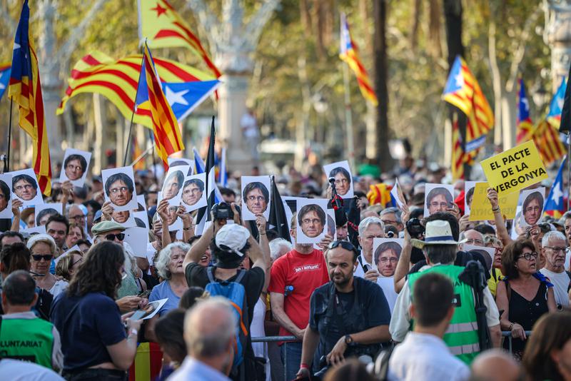 People with masks of Carles Puigdemont's face await the ex-president's return to Barcelona in August