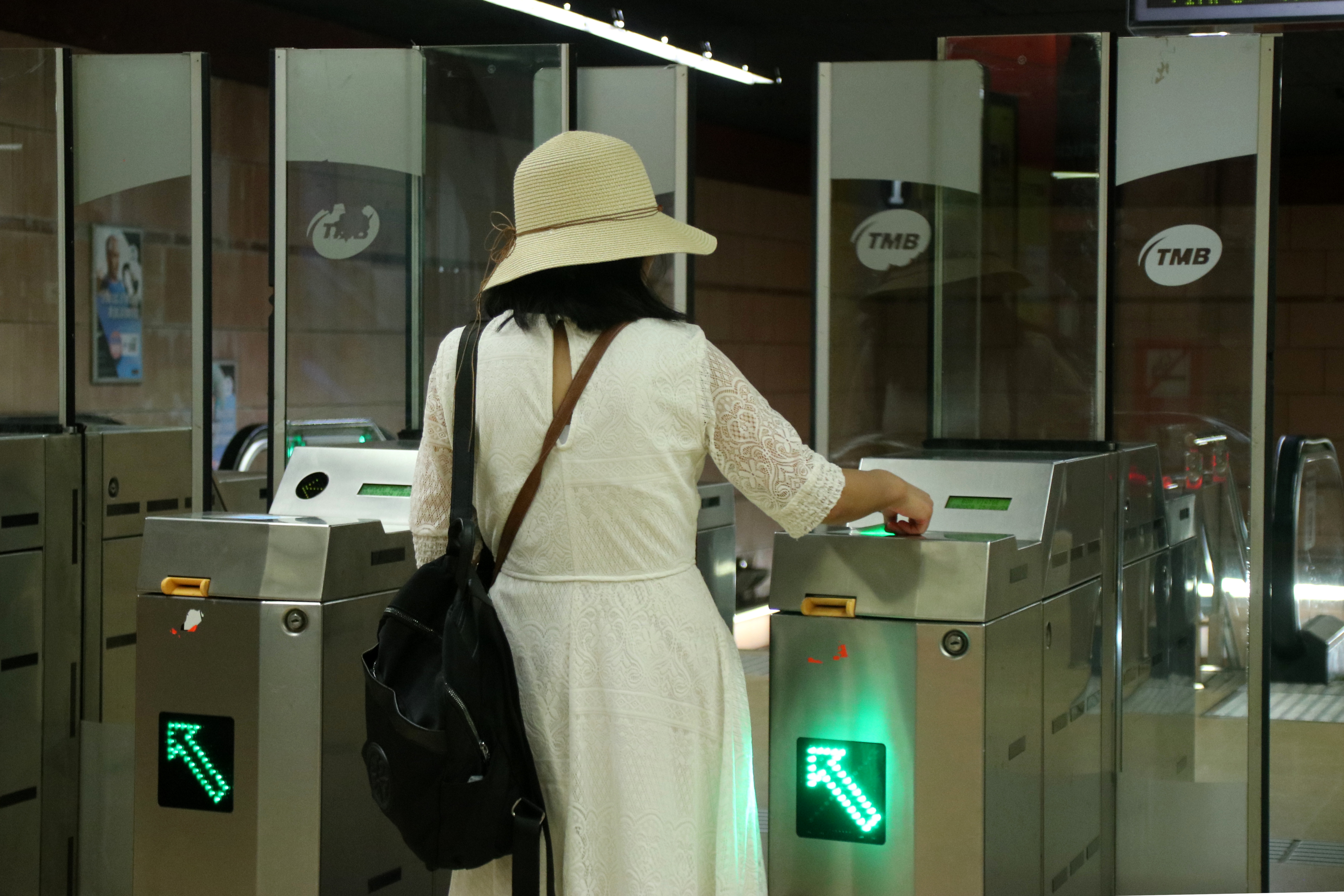 A traveler validates their T-mobilitat card on the Barcelona metro