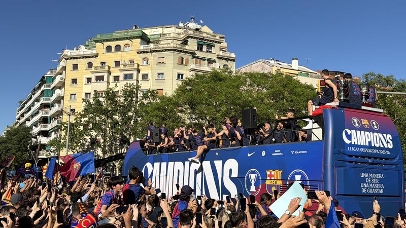 FC Barcelona players ride through the Catalan capital on an open-top bus as part of the celebration of the La Liga title