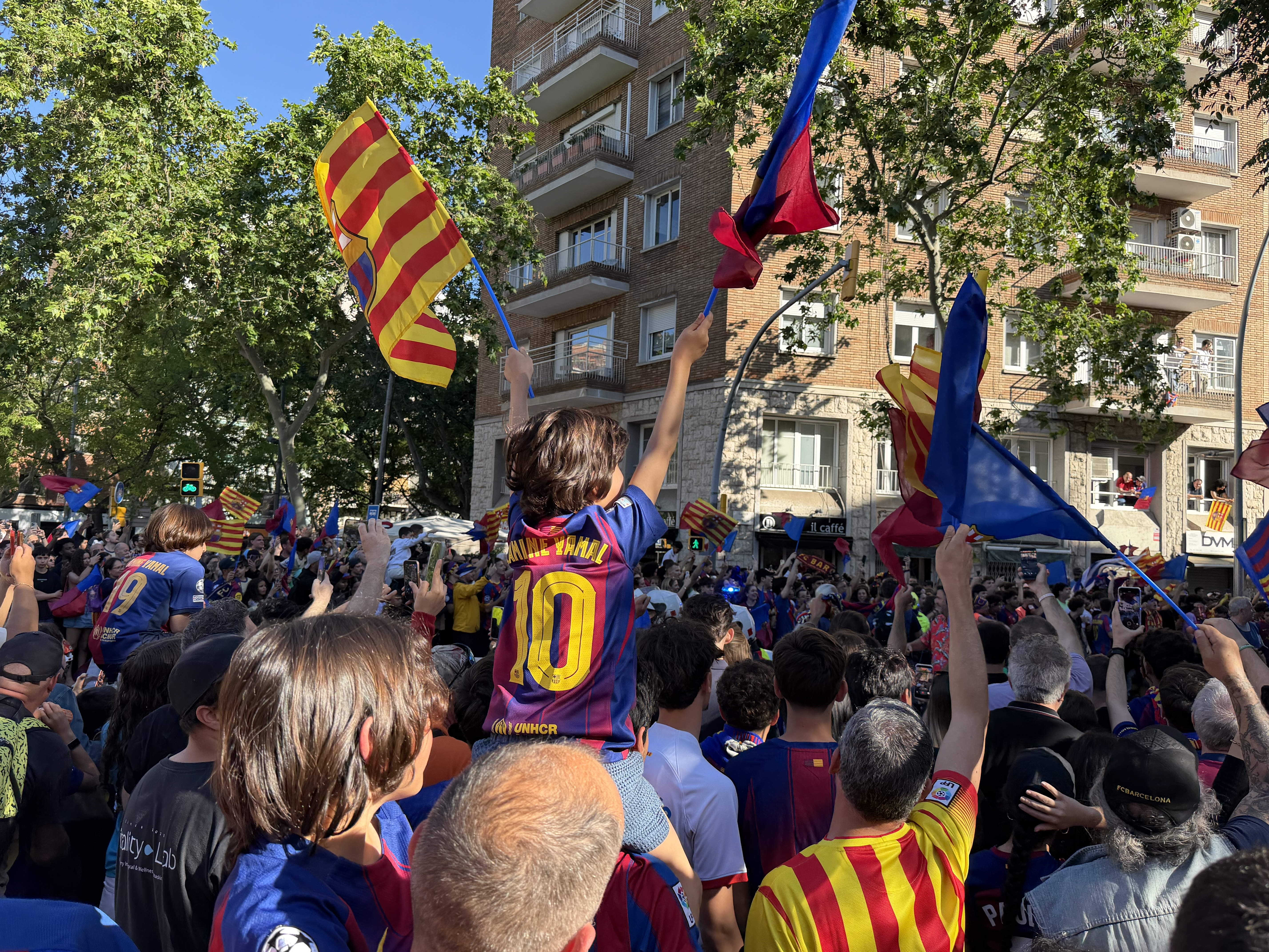A young Barça fan waves flags during the league title celebrations
