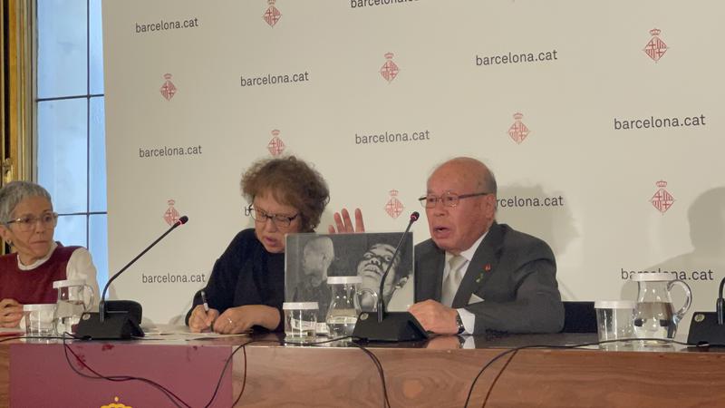 Shigemitsu Tanaka, 1945 atomic bomb survivor, holds up an image at a press conference in Barcelona