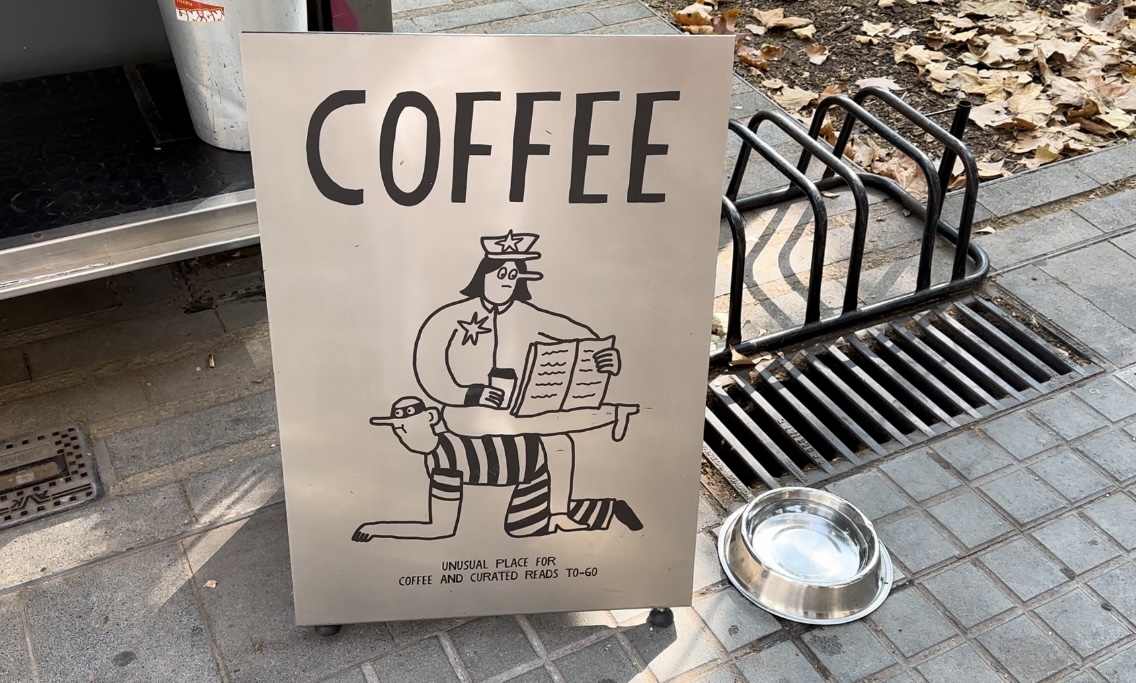 "Unusual place for coffee" poster seen at a News and Coffee stand