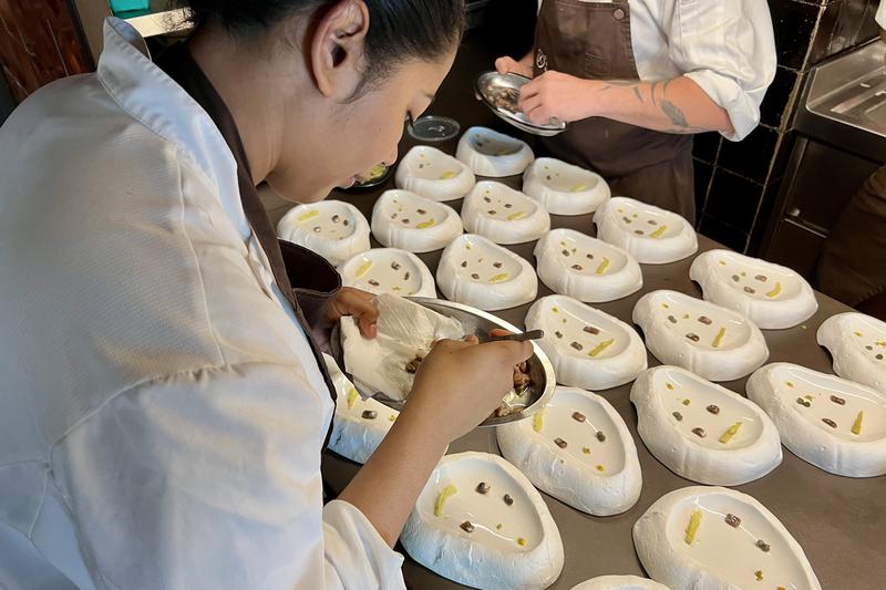 A cook prepares a meal at Disfrutar restaurant ahead of the first customers