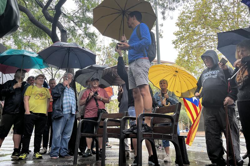 Pro-independence activists gather outside a Barcelona police station to protest against the arrest of four people planning an action against the La Vuelta cycling race