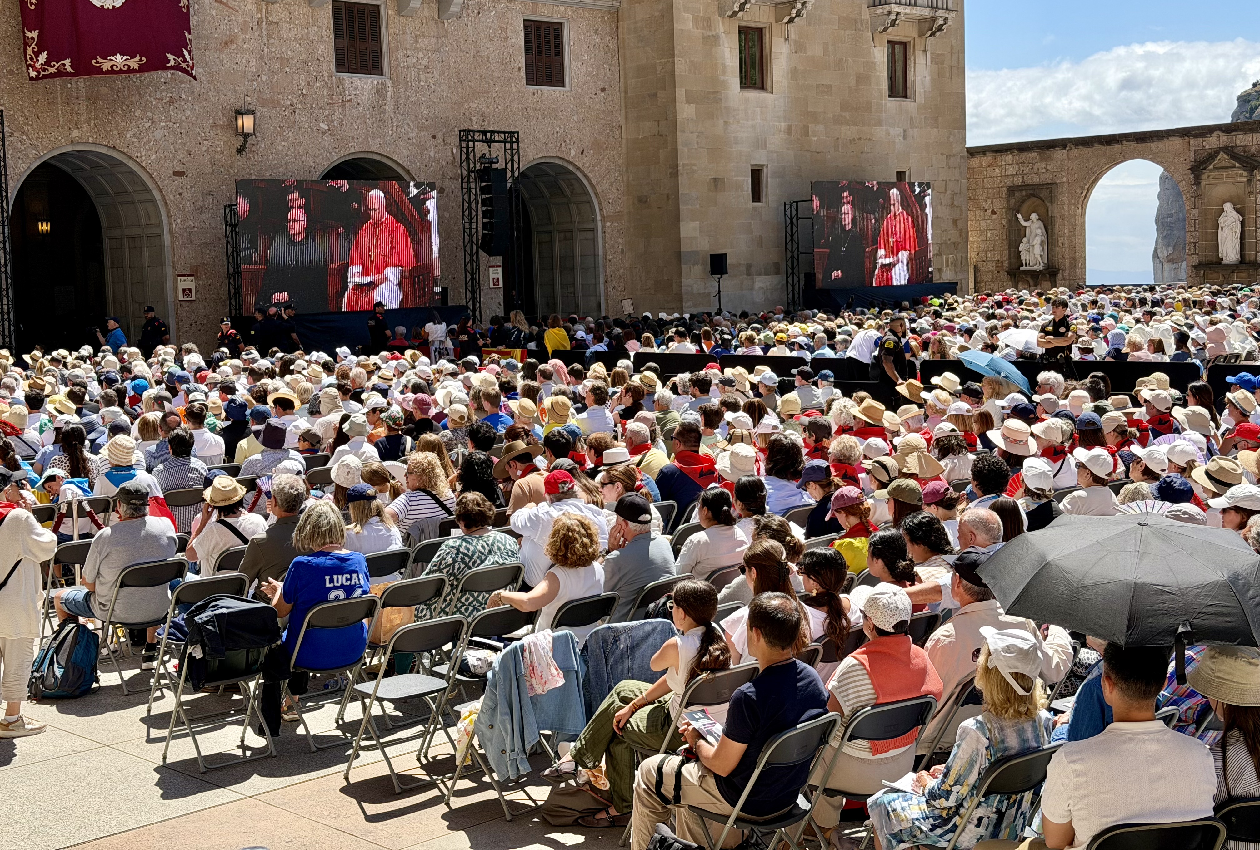 Those unable to enter the basilica follow the mass on screens outside