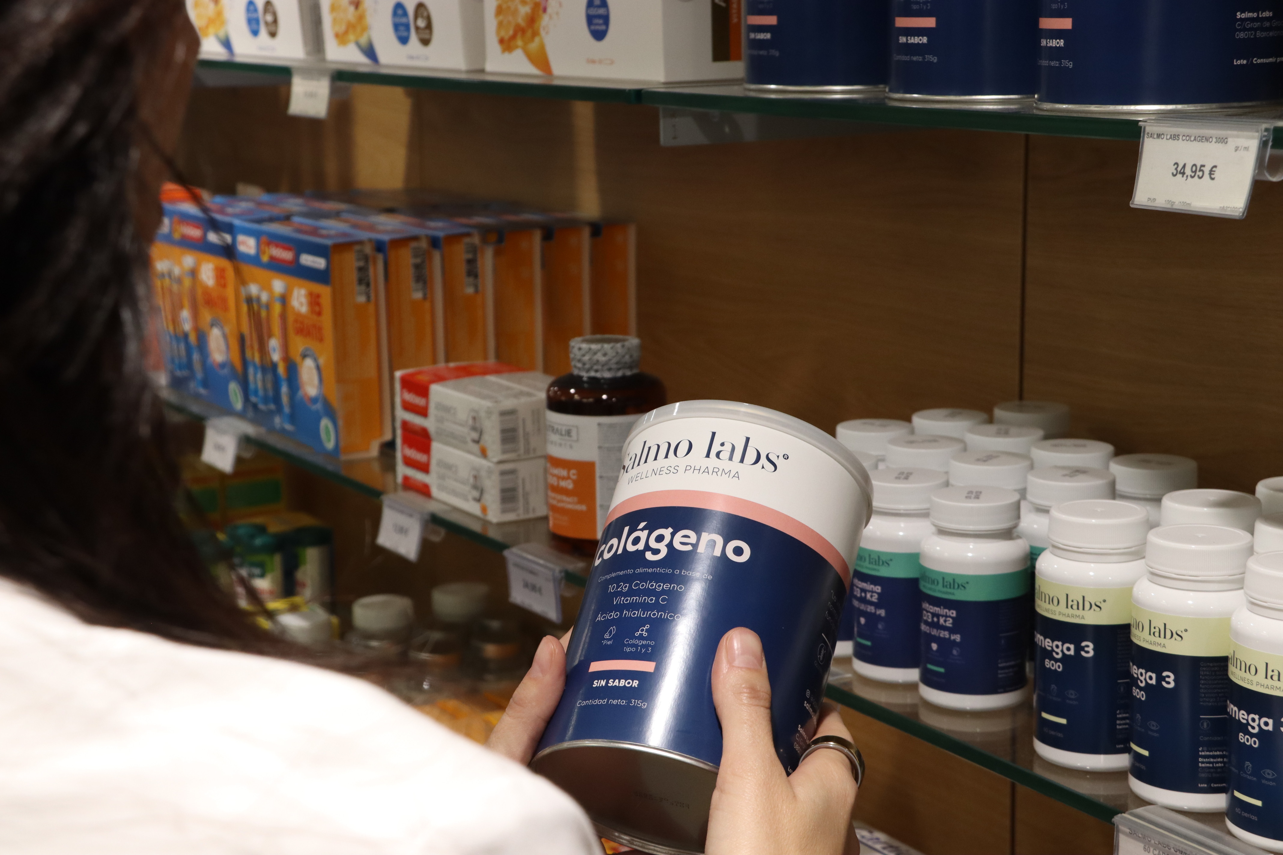 Pharmacist holding a bottle of supplements in a pharmacy