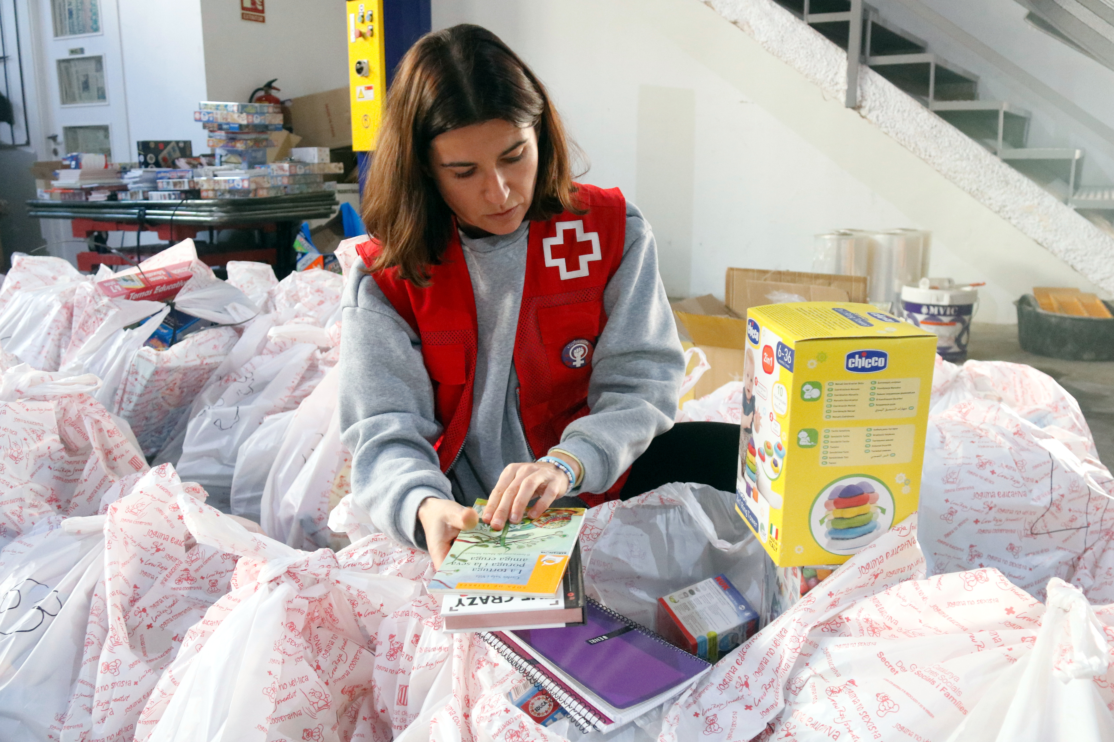 A Red Cross volunteer prepares books and toys for vulnerable children in Girona during the Christmas season