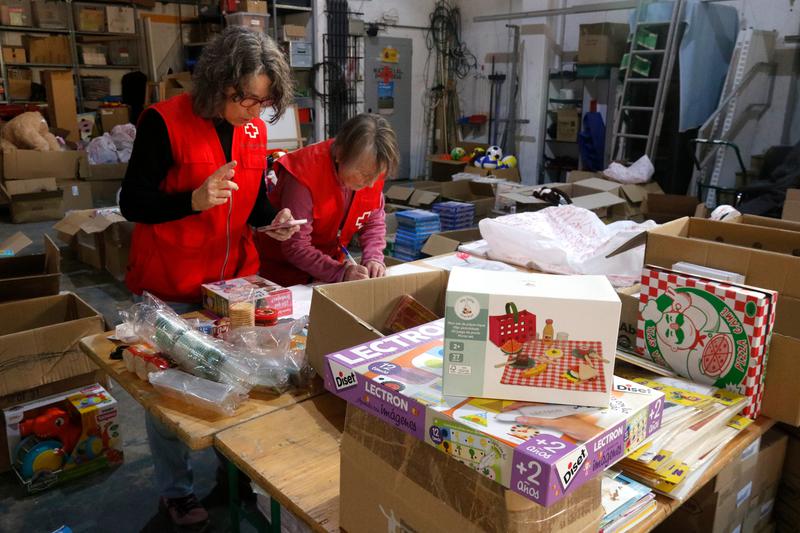 Red Cross volunteers in Girona preparing packs with toys and school supplies for vulnerable children