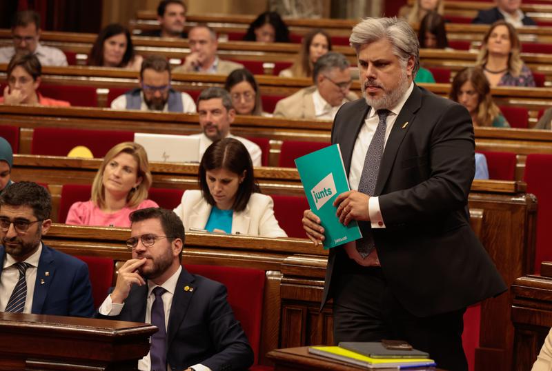 Junts per Catalunya spokesperson Albert Batet walks in front of the Catalan president, Pere Aragonès, during the general policy debate on September 27, 2022