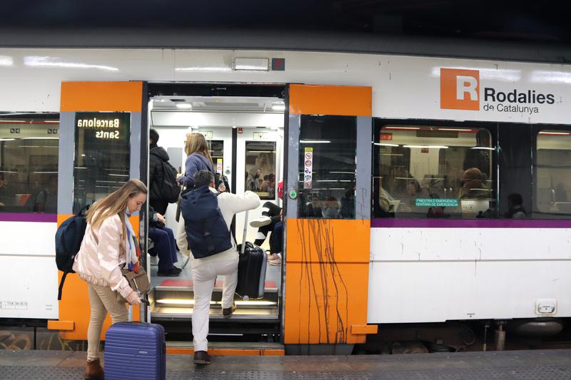 Renfe commuters getting on a train at Barcelona's Sants station on the first day of CGT strike, November 2022