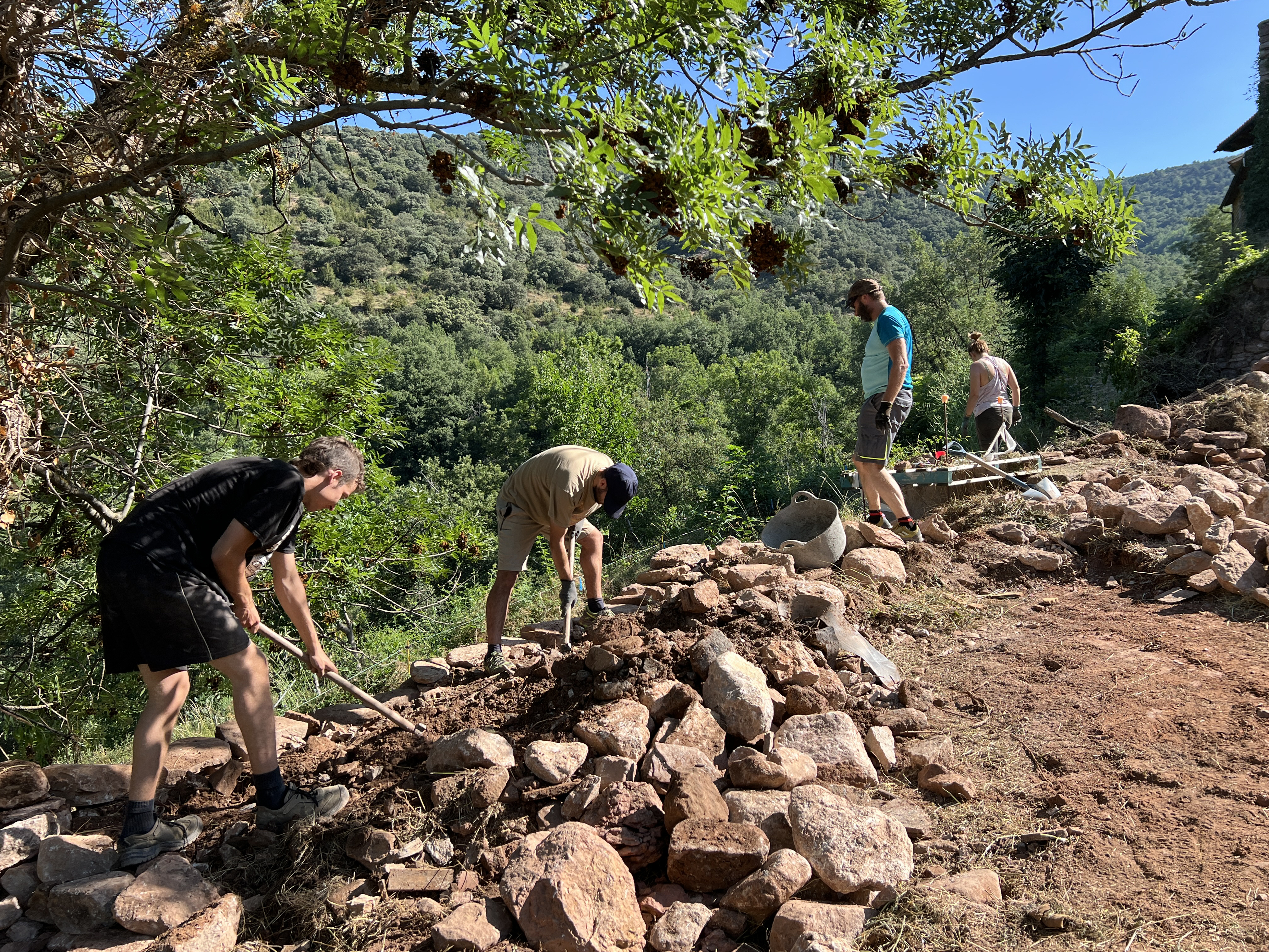 Voluntaris treballant en la recuperació del poble d'Envall, a la vall Fosca