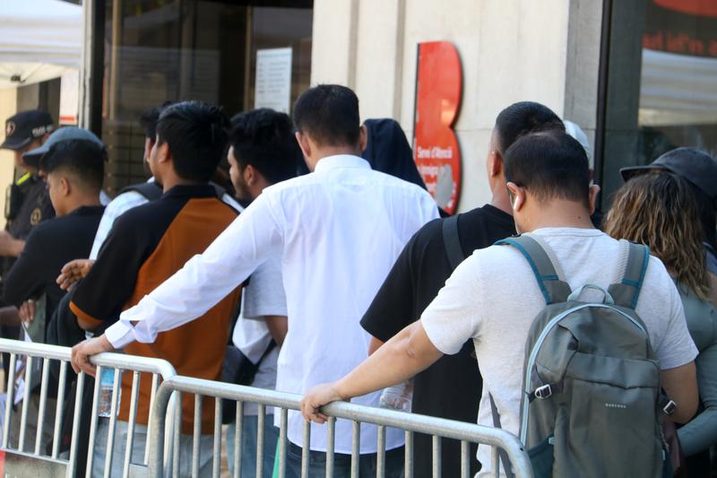 Migrants queue in Barcelona to submit their vulnerability certificate, one of the key documents required for regularisation
