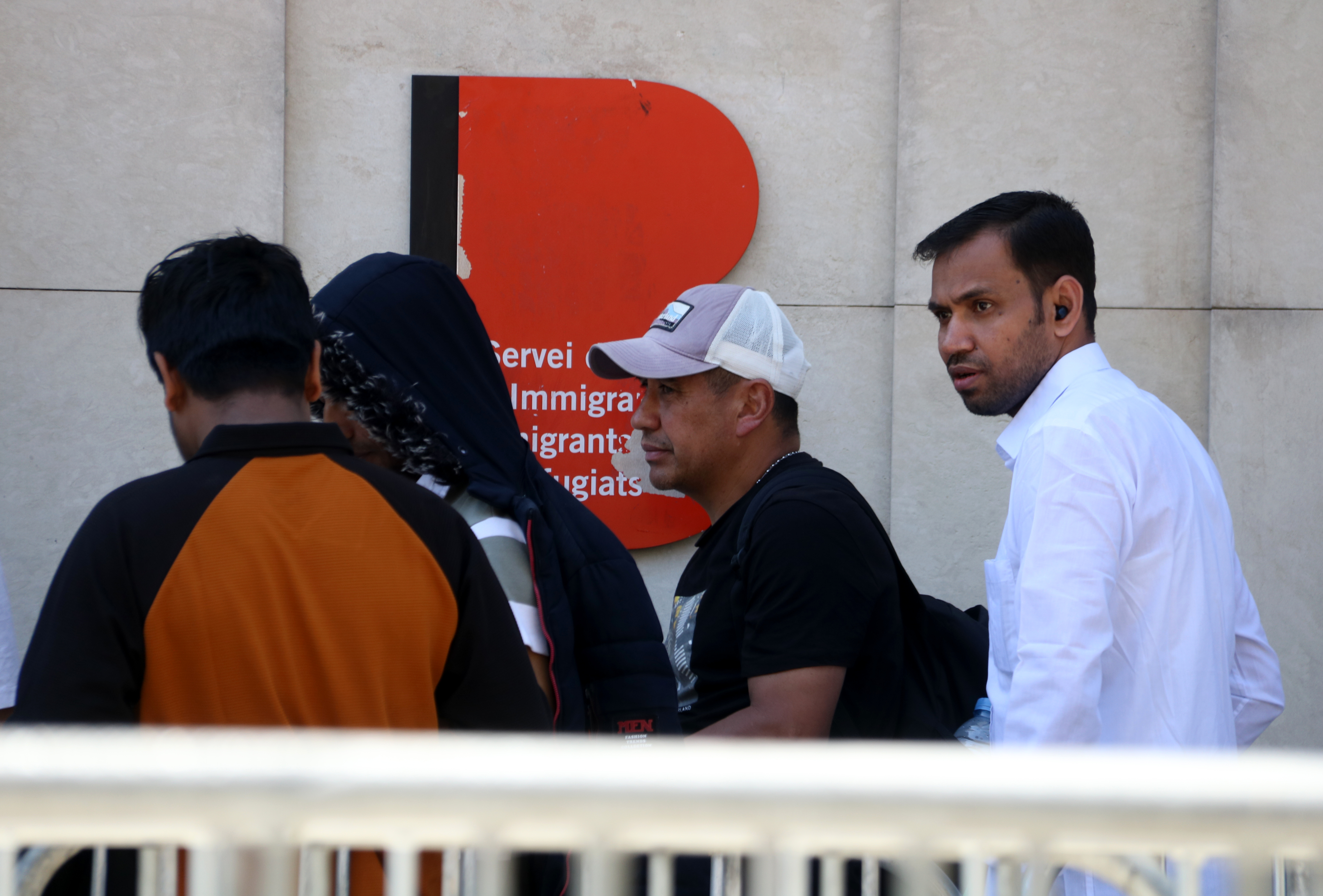 Migrants queue in Barcelona to submit their vulnerability certificate, one of the key documents required for regularisation