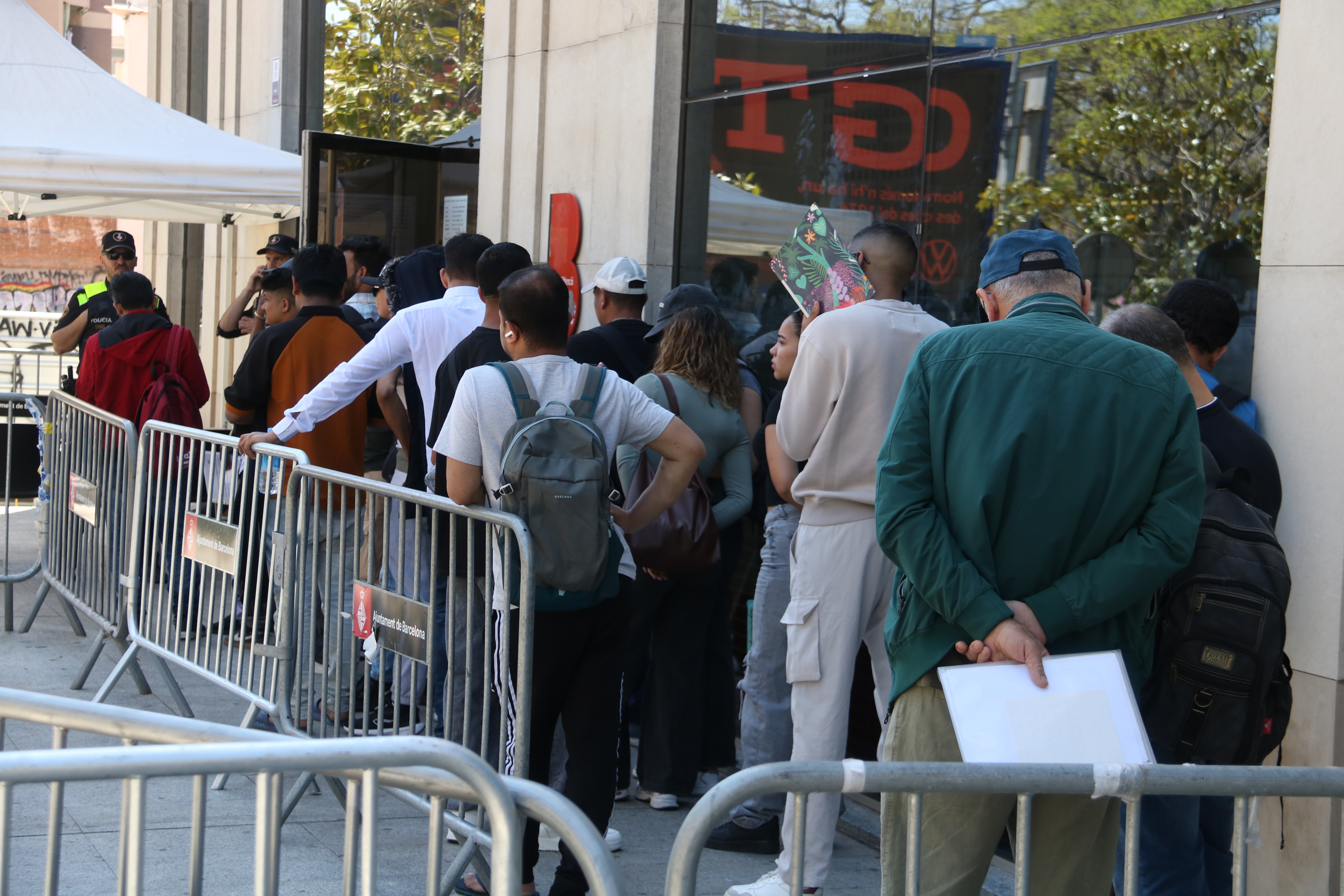 Migrants queue in Barcelona to submit their vulnerability certificate, one of the key documents required for regularisation