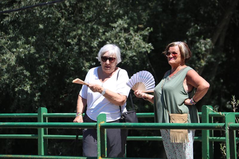 Two women cool themselves off with fans