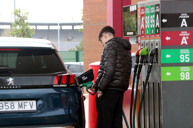 A young man filling up his tank at a gas station in L’Hospitalet