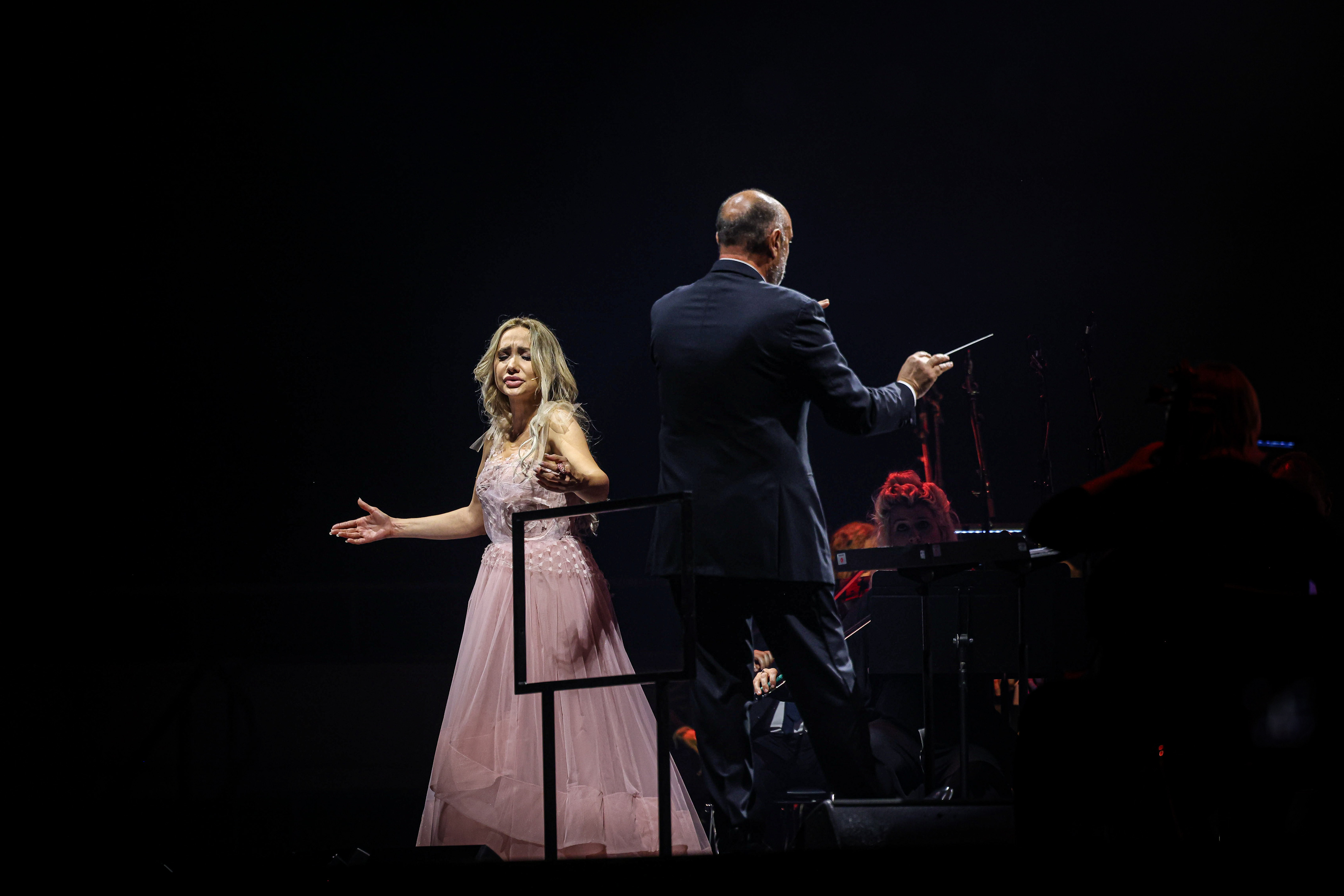 Soprano Cristina Pasaroiu sings besides director Carlo Bernini during Andrea Bocelli’s concert in Barcelona on April 30, 2024