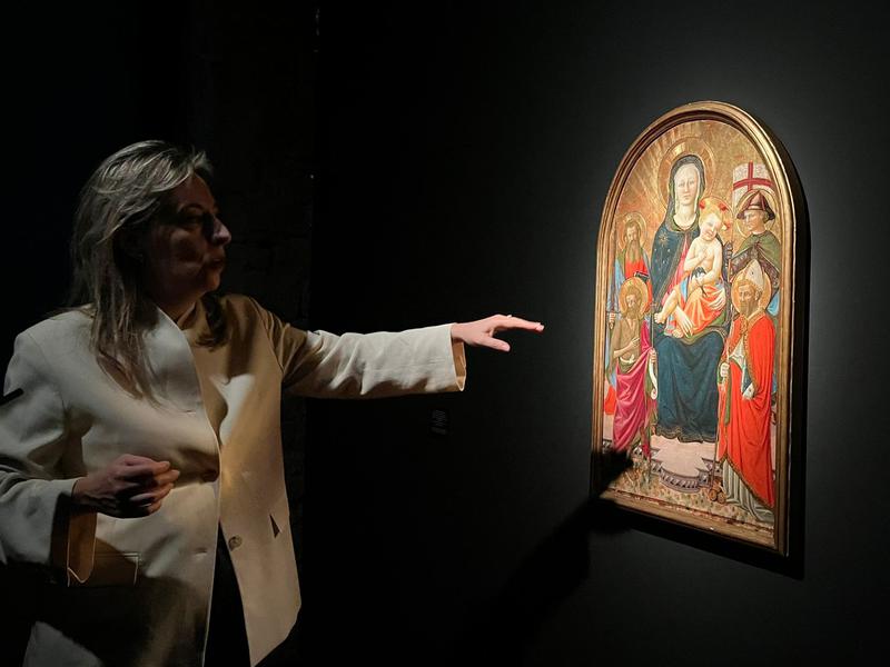 Helena Alonso, curator of the exhibition, standing beside "Madonna and Child"