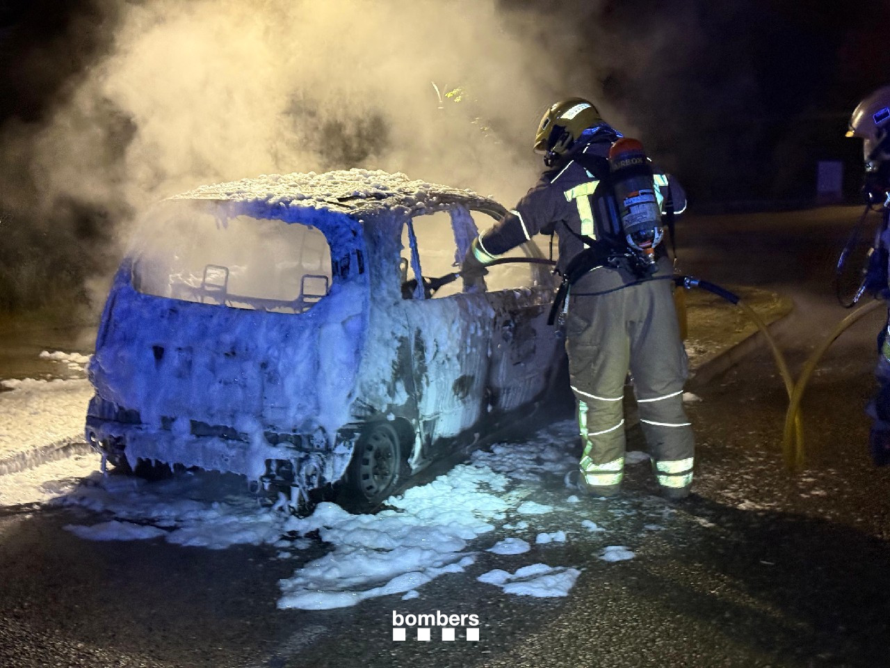 Firefighters extinguish a burning car during Sant Joan in 2025