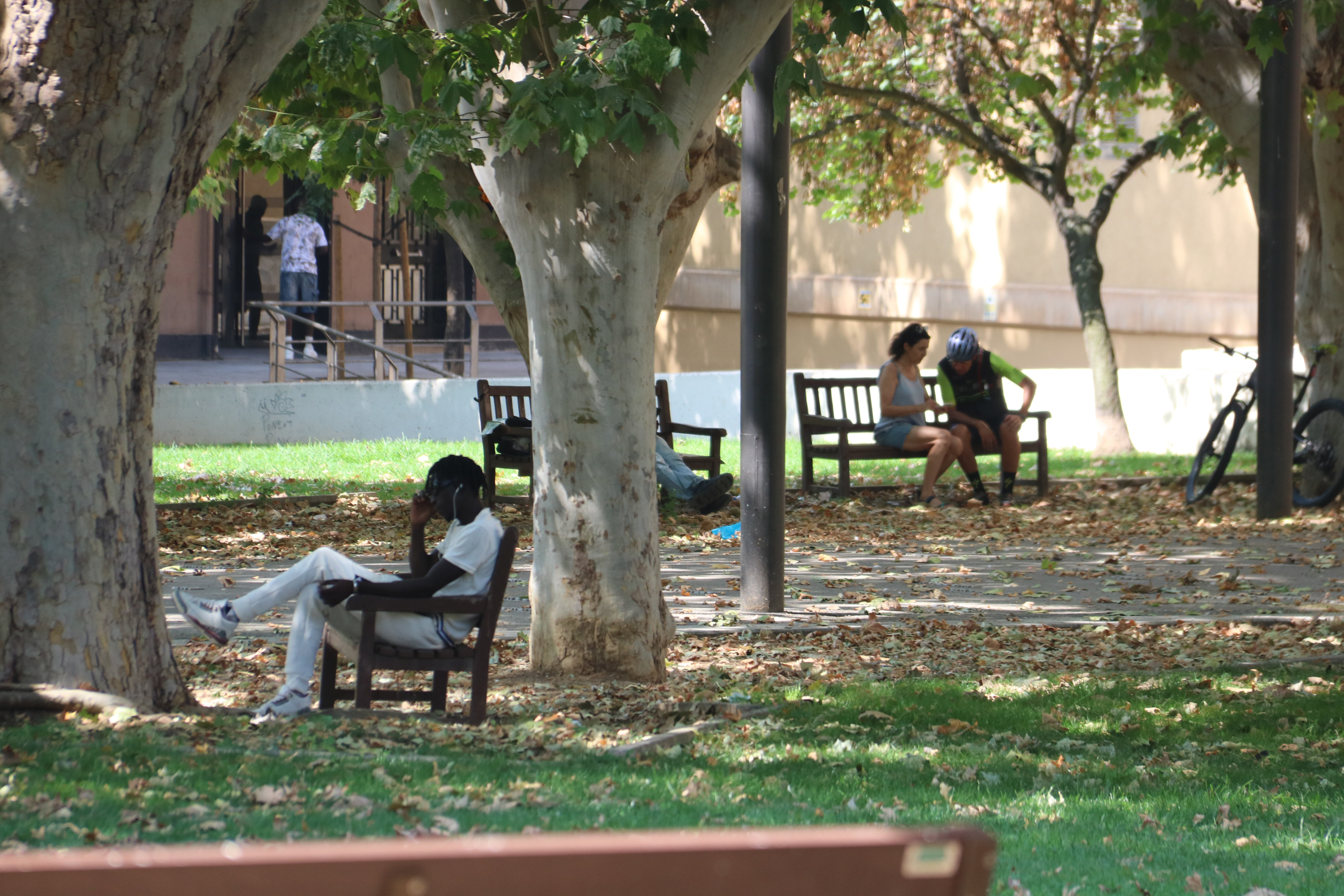 People making use of the shade in a park in Lleida during the heatwave