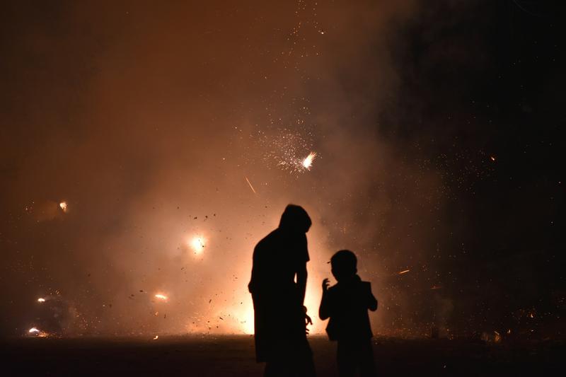 A couple of people standing in front of a fire