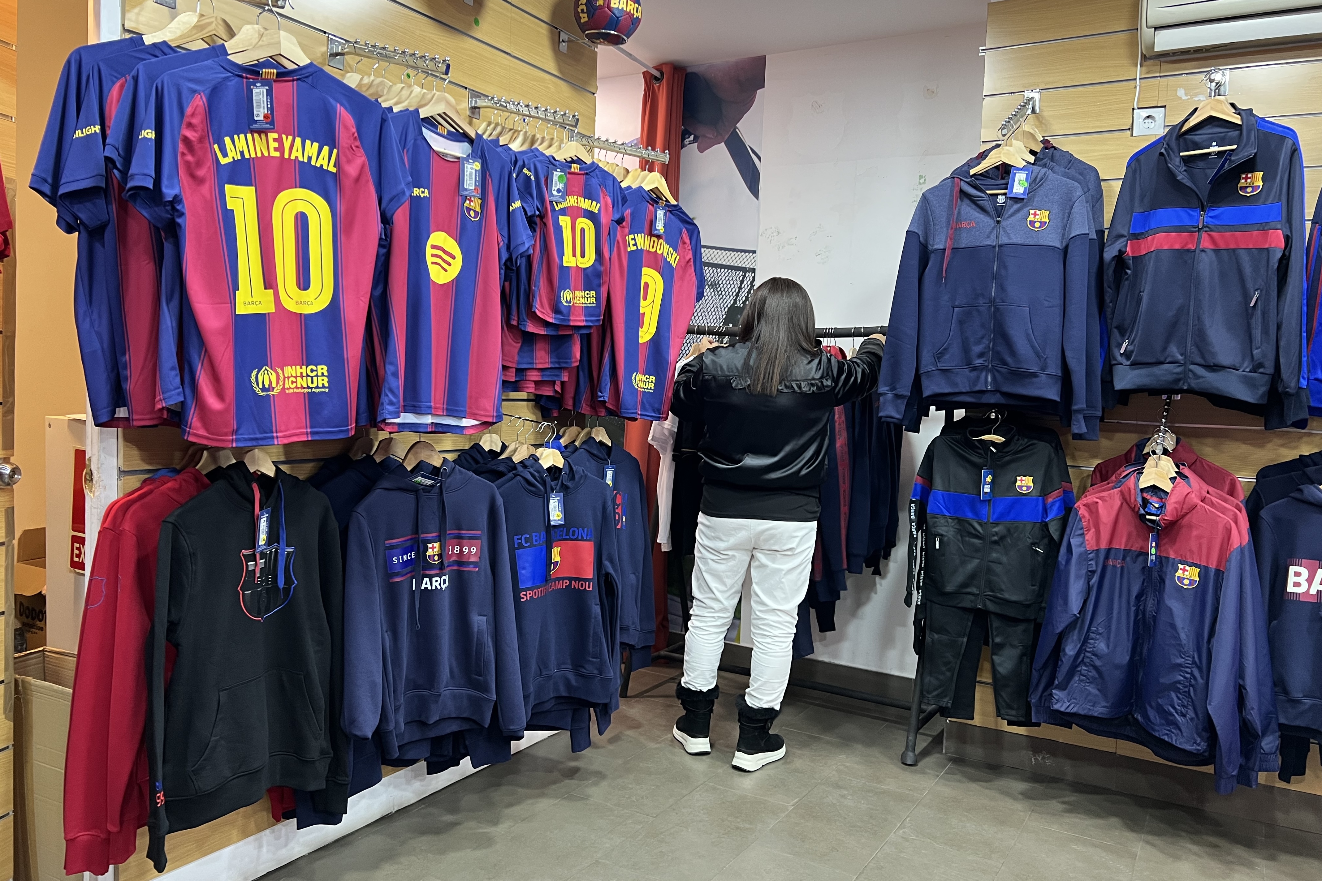 A worker sets up several Barça jerseys at a store near Spotify Camp Nou ahead of the first game back at the stadium