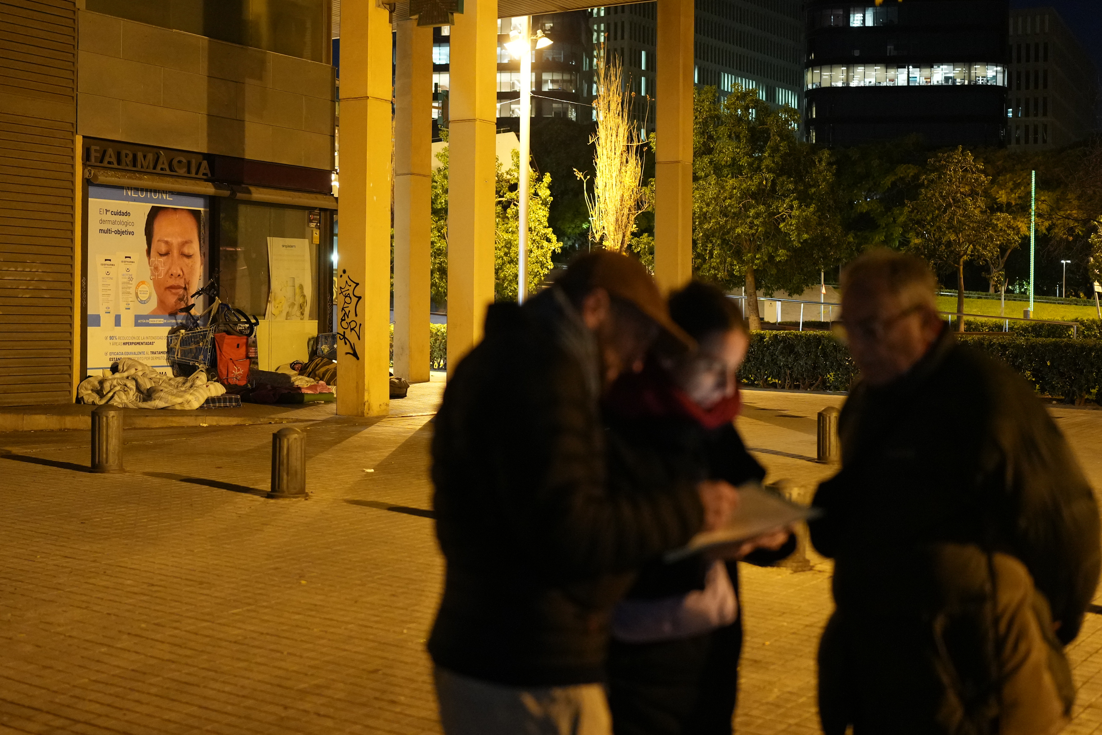 Three Arrels volunteers near two people sleeping rough during a count of homeless people in Barcelona