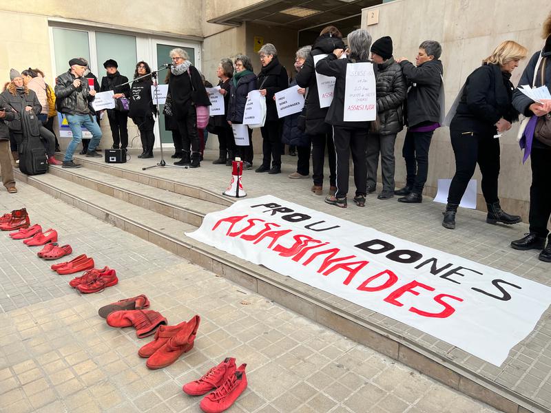 Women at a demonstration in Vic hold up posters of the names and ages of women killed by their partners in December and January 